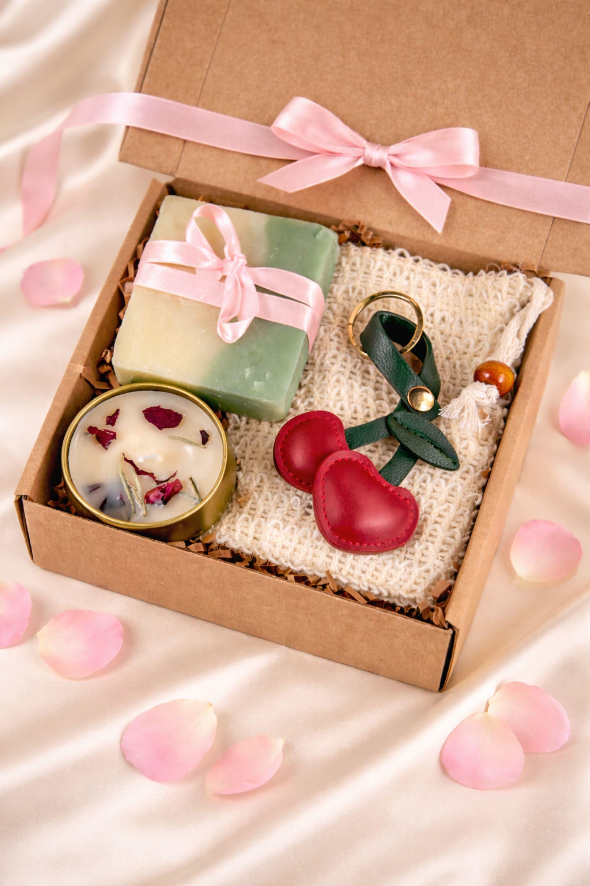 Cozy comfort gift box with handmade soap tied with red ribbon, natural candle in metal tin with dried petals, crocheted washcloth and leather cherry keychain arranged in a kraft box with eco filler. Thoughtful handmade care package perfect as a thinking of you gift, long distance gift, just because present or comforting cozy gift for her. Warm meaningful gift box designed to bring comfort, care and emotional warmth.