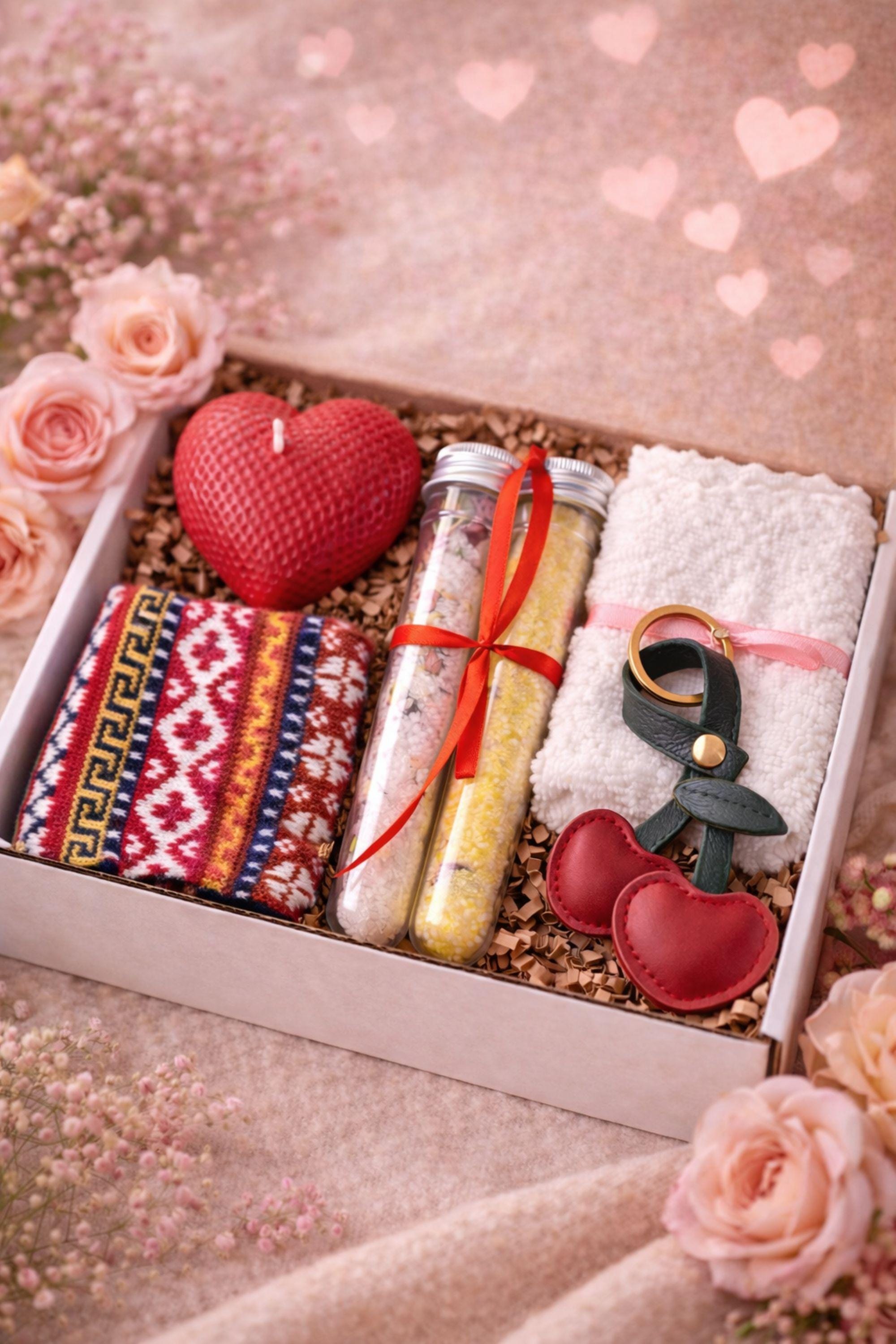Romantic Valentine gift box styled with soft florals and warm tones, showcasing a handmade heart candle, bath salts, cozy socks, washcloth, and leather heart keychain. Cozy Valentine care package designed as a heartfelt handmade gift for her, perfect for celebrating Valentine’s Day with love, affection, and emotional connection.