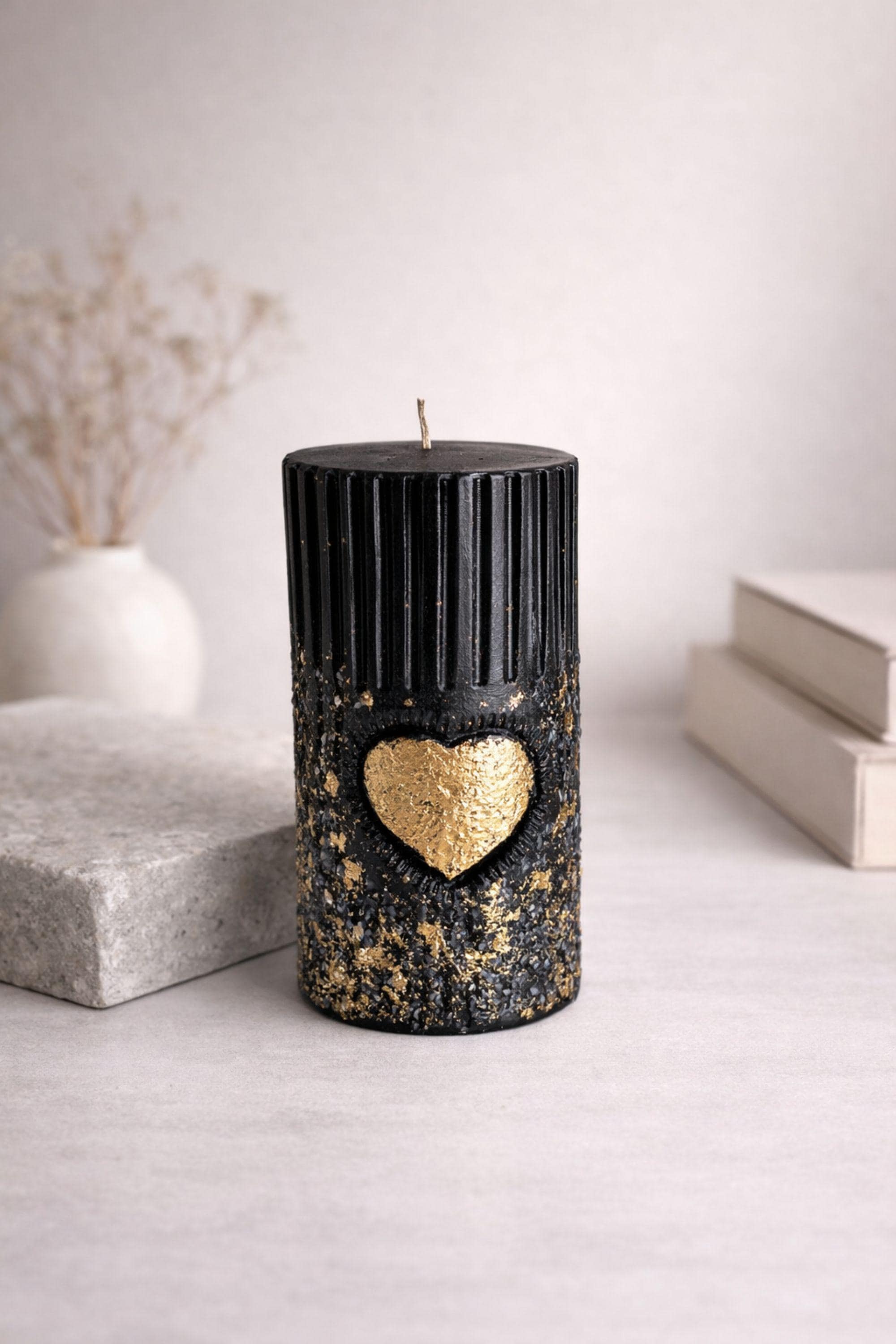 Black gold sculptural candle on coffee table with book and coffee, modern home decor candle, luxury decorative candle, minimalist interior styling, aesthetic statement candle for living room decor