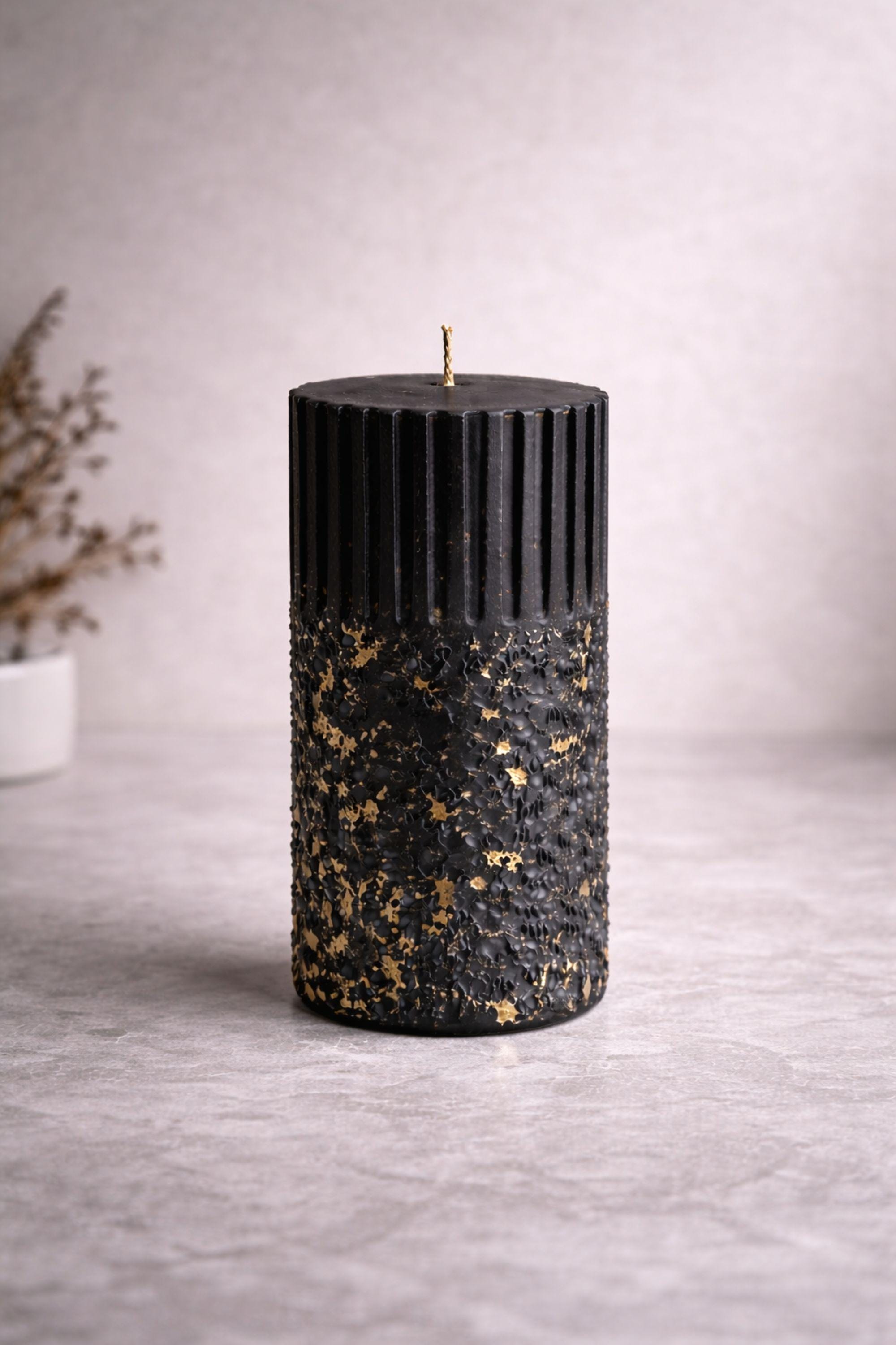 Handmade black wax sculptural object shown strictly vertical to highlight balanced proportions and architectural form. The ribbed surface and textured base with gold flecks are presented in a minimal composition that reinforces form-first design and material focus.
