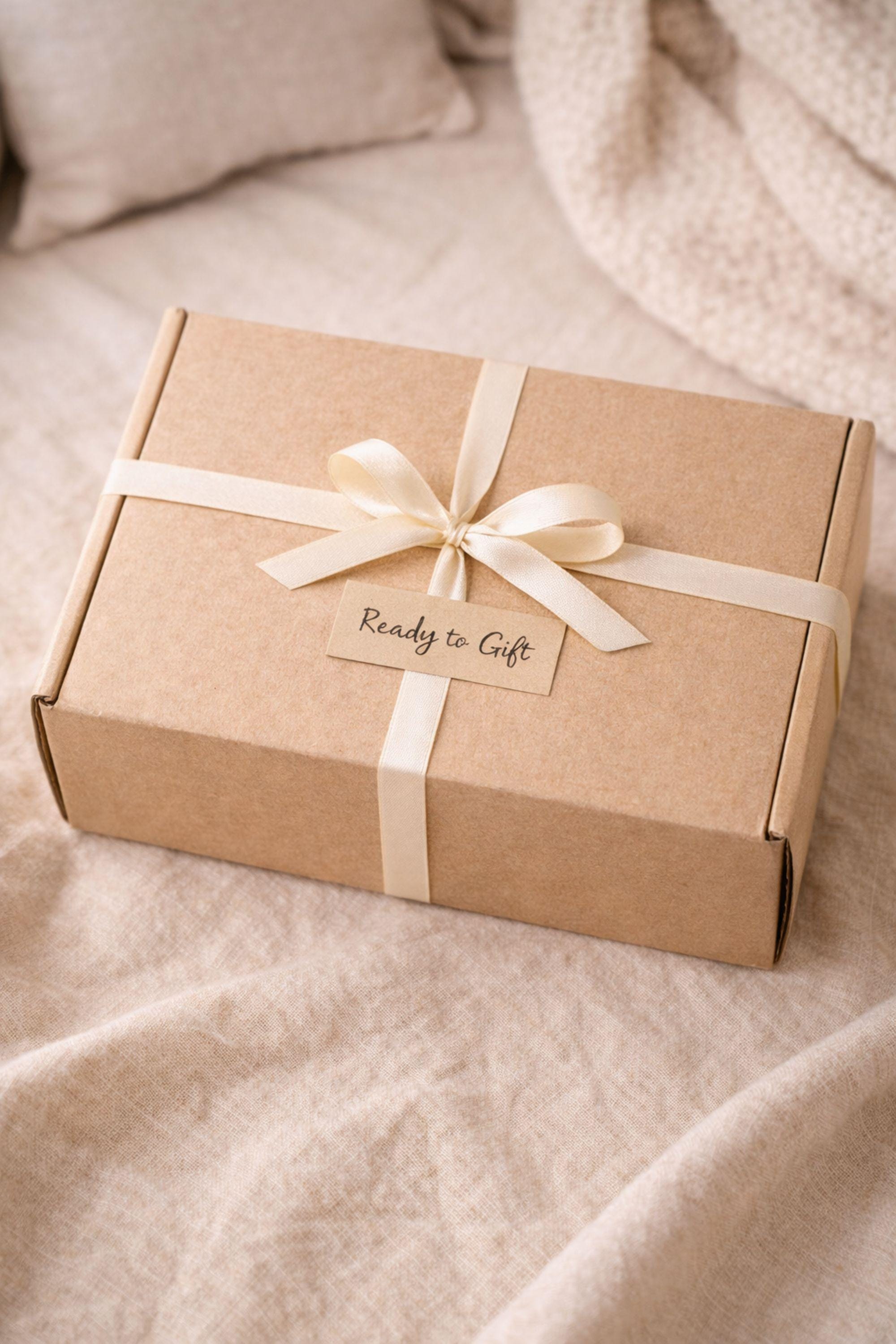 Thinking of you gift box with handmade heart candle, cozy knitted socks, bath salt tubes tied with red ribbon, soft cotton washcloth, and leather heart keychain arranged inside a kraft gift box. Small meaningful comfort gift designed as a care package for her, perfect for sending love, warmth, and support during long distance moments, stressful times, or just because. Handmade cozy gift set ready to give.