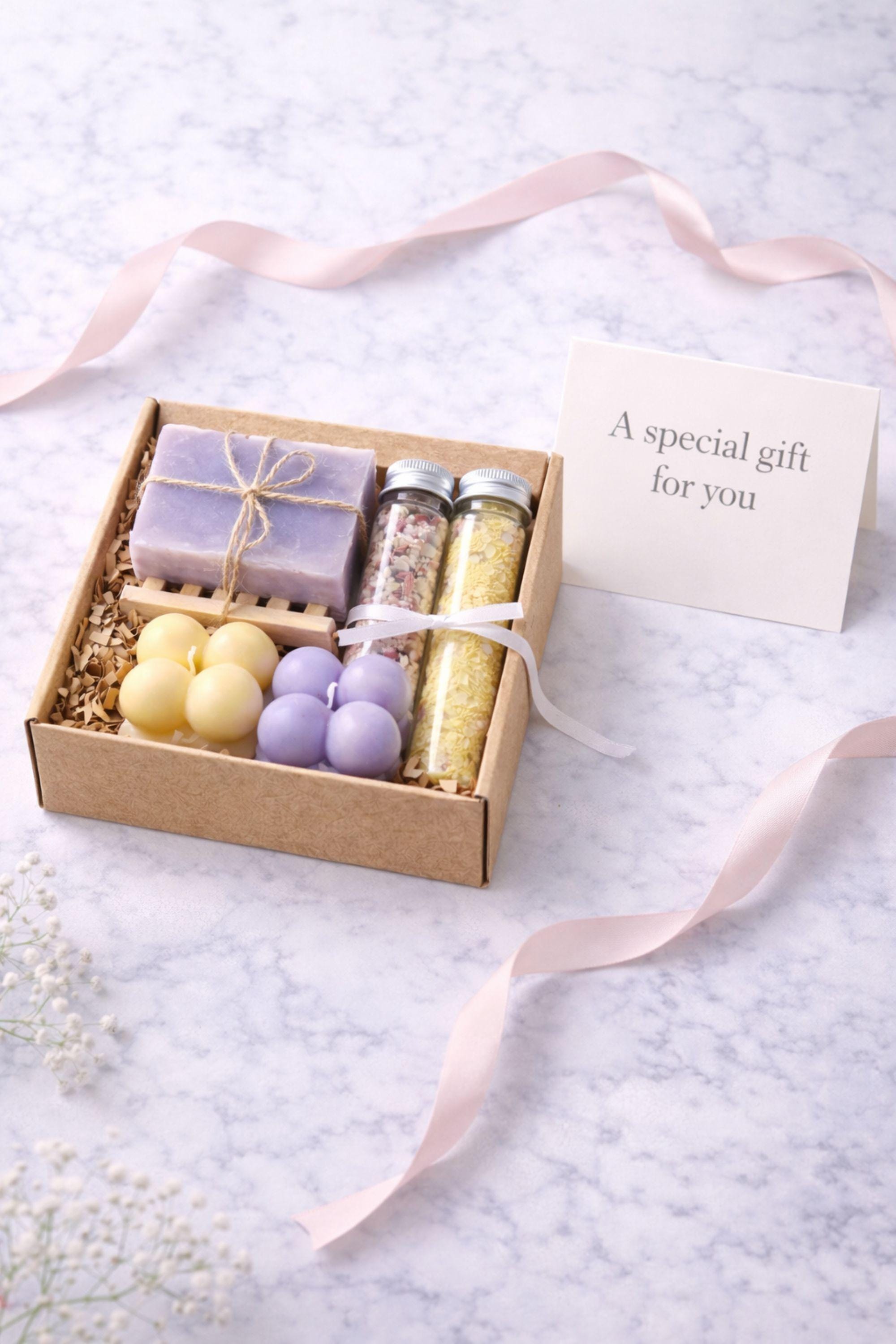 Gift moment photo of an open handmade gift box for her placed on a clean surface, showing candles, soap, and bath salts arranged neatly inside. Universal gift presentation designed to highlight how the gift looks when opened, focusing on thoughtful packaging rather than lifestyle or family context.
