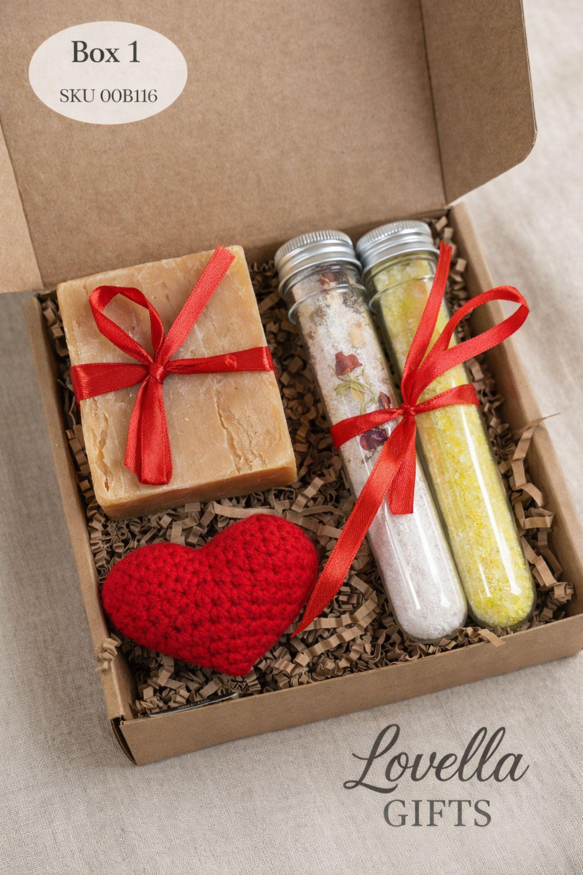 Open kraft gift box showing the exact contents of this romantic gift for her, including a handmade heart candle, natural soap with red ribbon, and two bath salt tubes. The arrangement accurately represents the real box size and items included. This handmade love gift set is designed to provide a clear and honest view of what is included, perfect for buyers searching for a romantic candle and soap gift box.