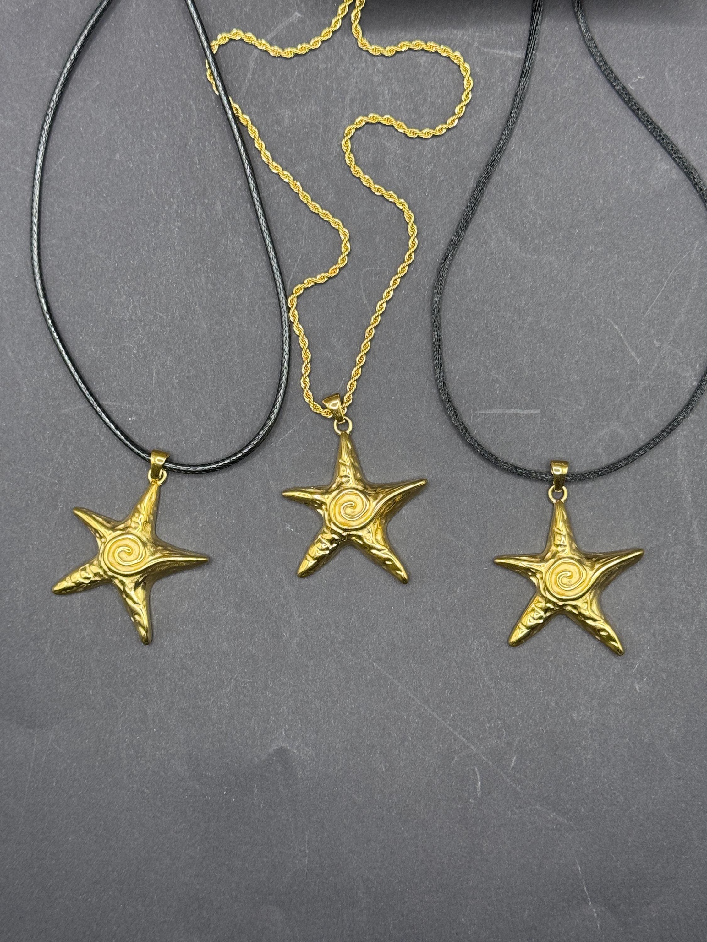 Coastal Star Necklace presented in a gift box on a beach background.
