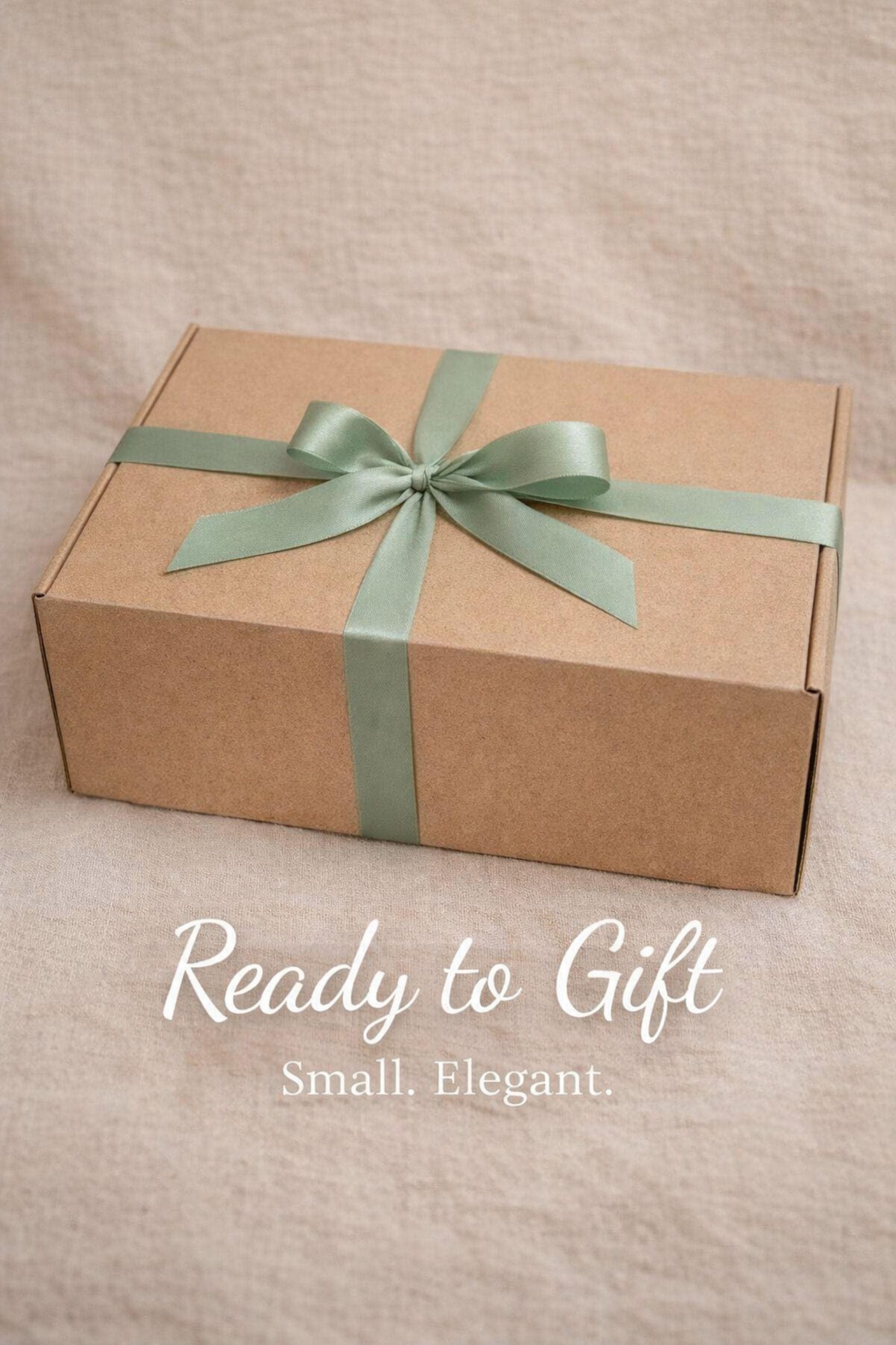Sending You Hugs grief support gift box with sage knit blanket, ribbed green ceramic mug, handmade two-tone artisan soap, stainless steel spoon, and three bubble candles arranged inside kraft box on warm beige linen background. Sympathy care package designed for comfort during difficult times, loss support, thinking of you gift, and emotional encouragement.