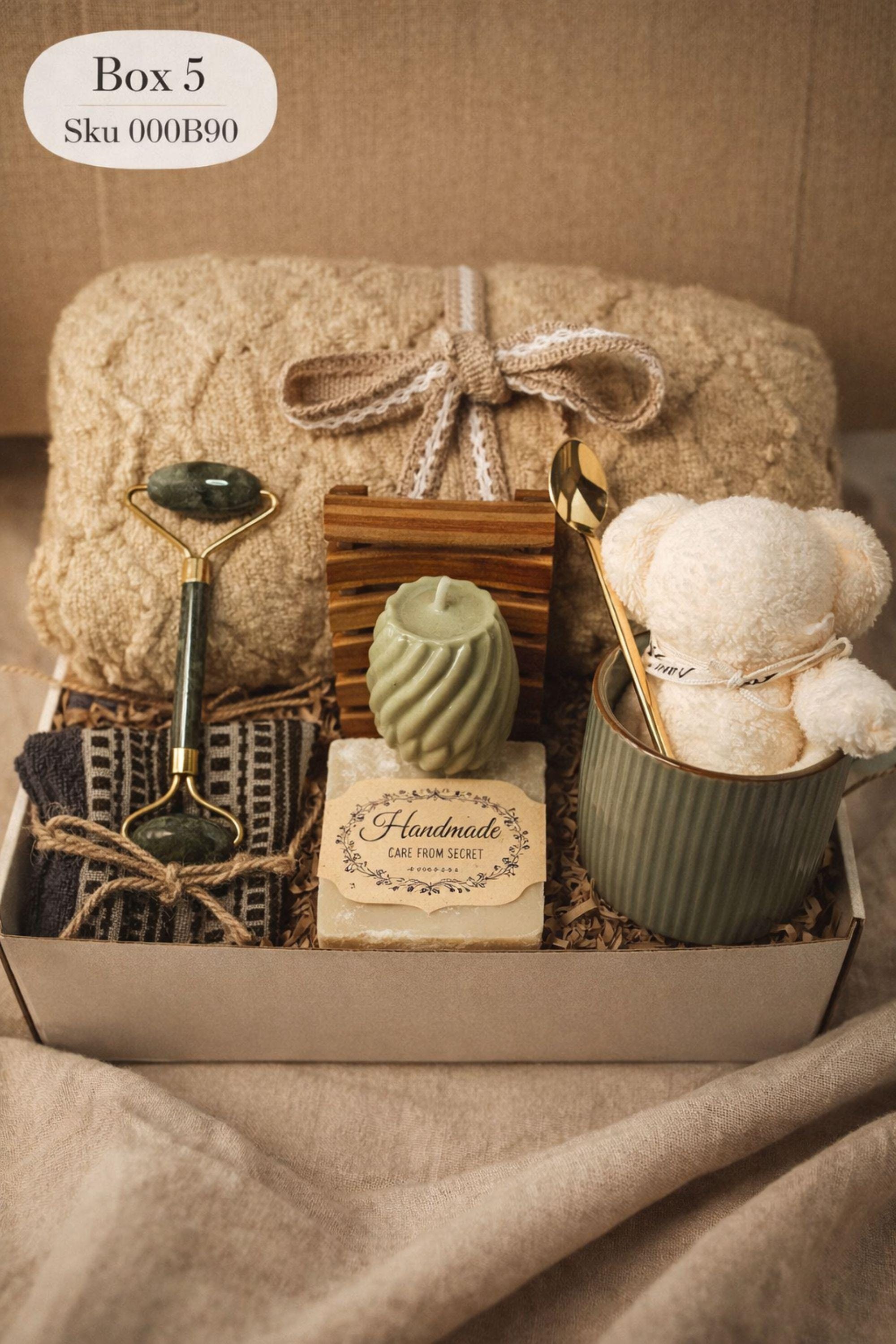 Sending You Hugs grief support gift box with sage knit blanket, ribbed green ceramic mug, handmade two-tone artisan soap, stainless steel spoon, and three bubble candles arranged inside kraft box on warm beige linen background. Sympathy care package designed for comfort during difficult times, loss support, thinking of you gift, and emotional encouragement.