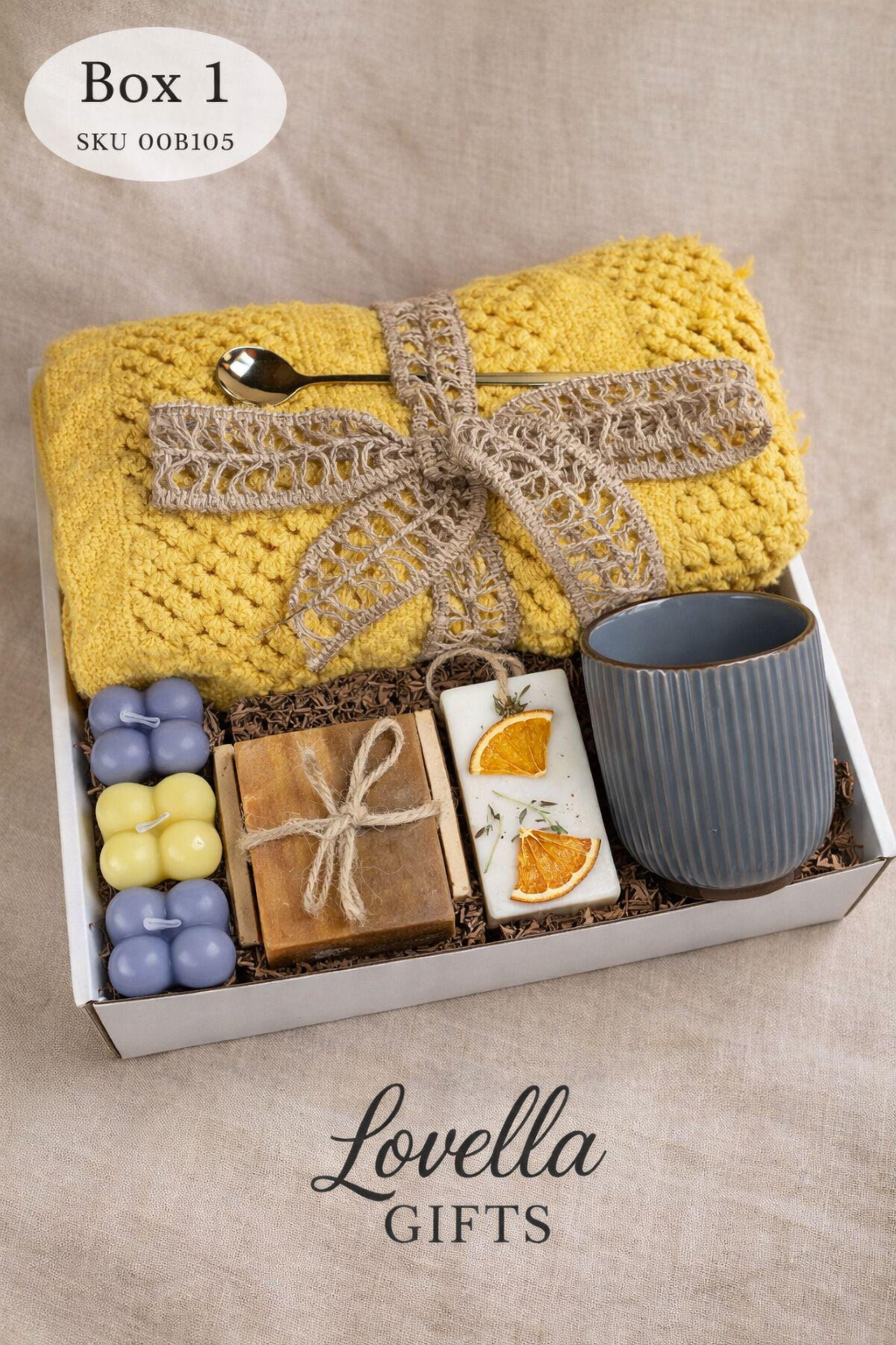 Self Love Reset gift box for women displayed on warm neutral linen background with soft window light, featuring yellow knit blanket, handmade natural soap, pastel bubble candles, citrus wax tablet with dried orange slices, ceramic mug and wooden soap dish. Emotional healing care package for new beginnings, self care gift for her, breakup recovery support box, thoughtful reset present.