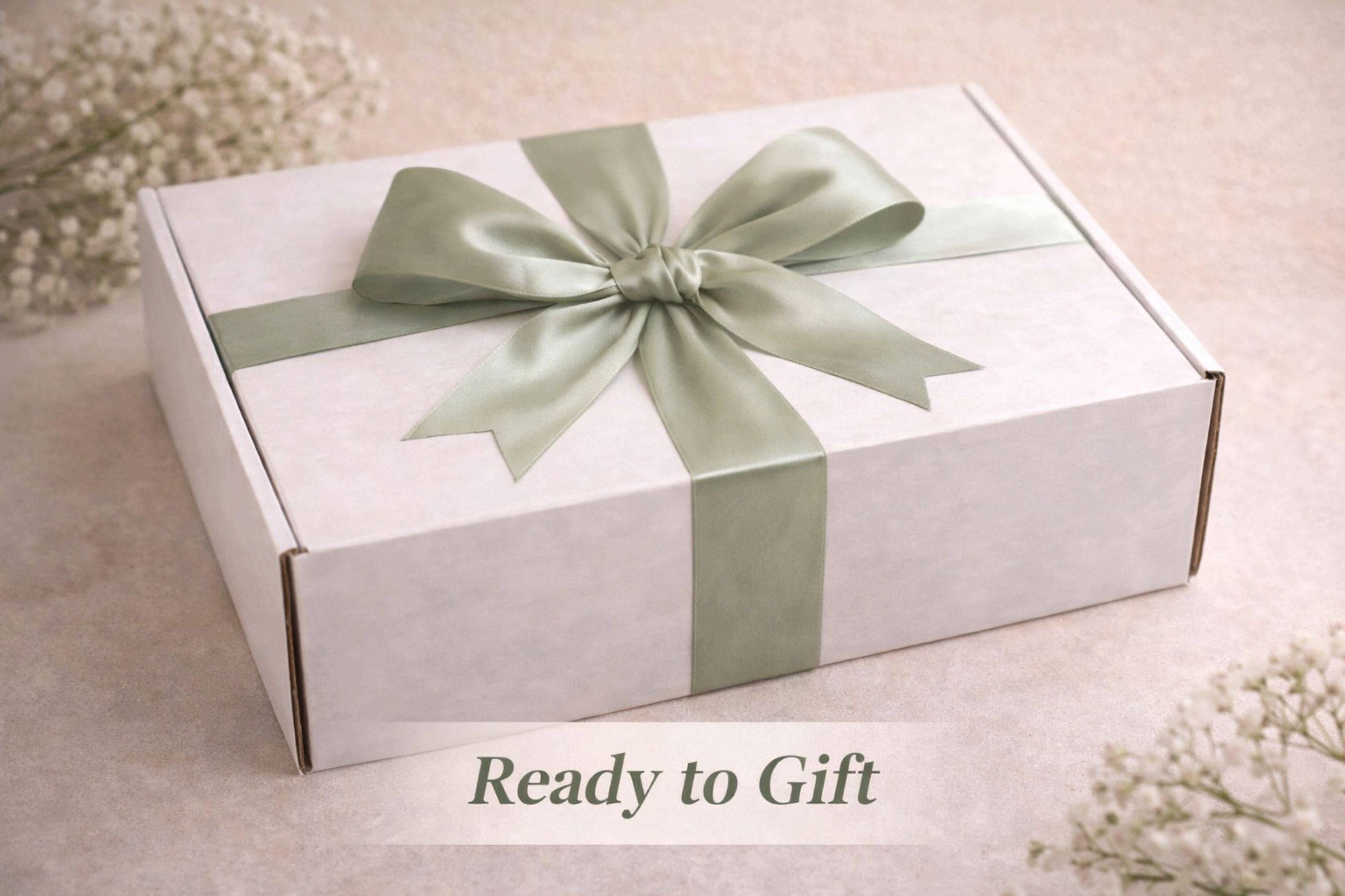 Easter gift box for women featuring a cozy knit blanket tied with green ribbon, ceramic mug with spoon, handmade artisan soap, soft socks, two lemon shaped soaps, decorative spring carrots and bunny accent arranged inside a gift box. Spring self care gift basket and Easter care package alternative to traditional Easter baskets, perfect Easter present for mom, sister, friend or women who enjoy cozy comfort gifts.