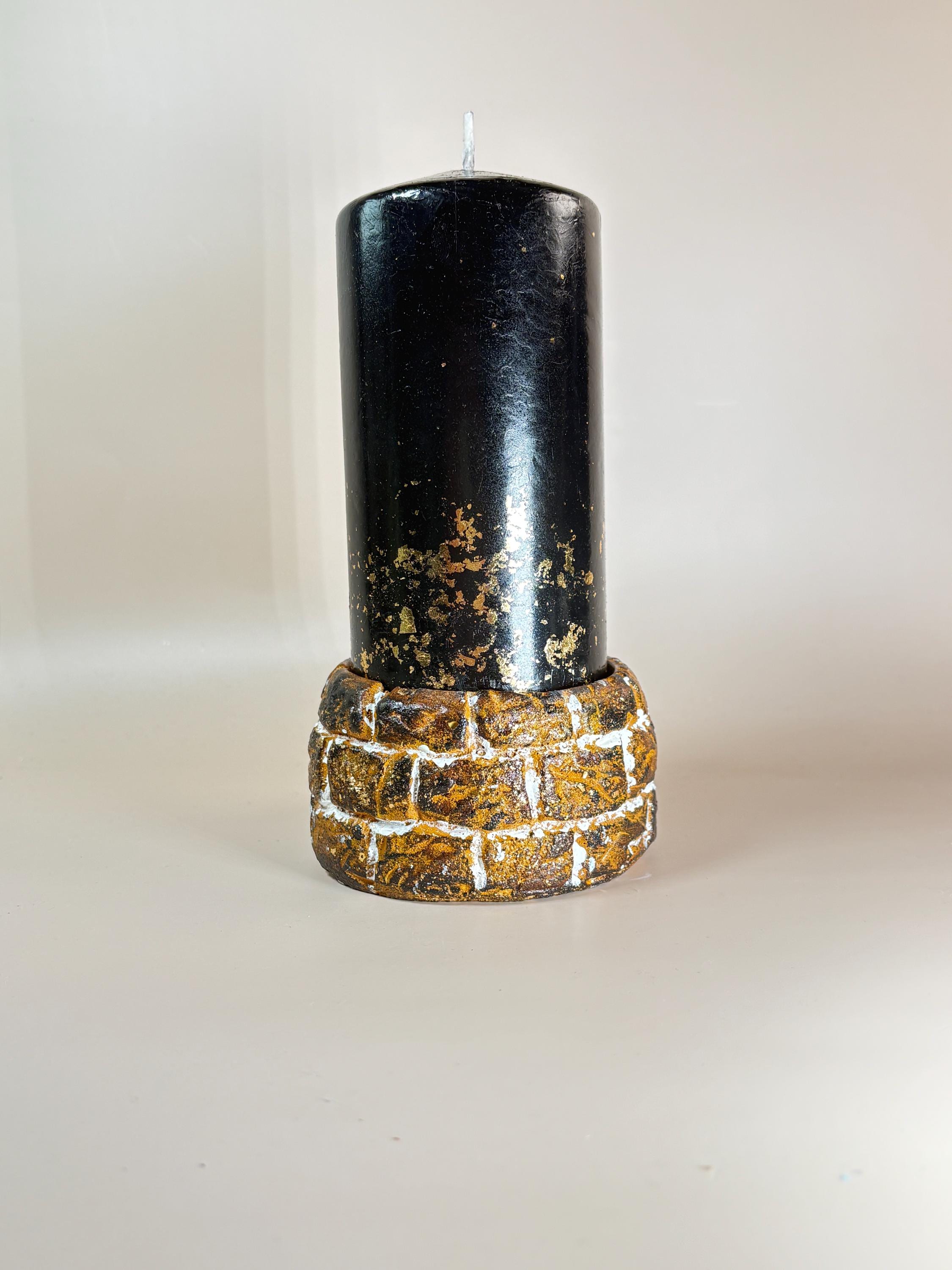 Luxury black pillar candle with gold flakes on textured stone holder, minimalist aesthetic home decor candle, elegant gift for her, modern neutral background