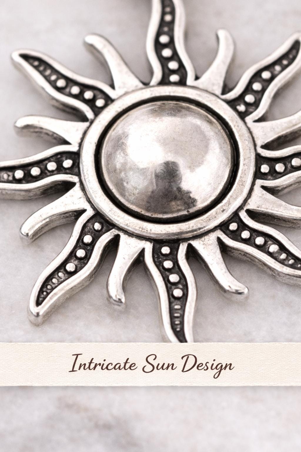 silver sun pendant necklace macro close up detailed sun rays texture celestial jewelry minimalist sun charm high detail product photo