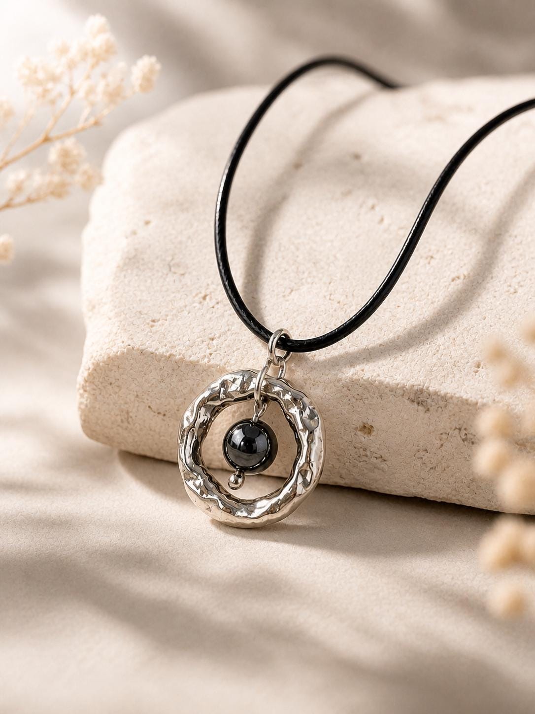 hematite necklace on stone background silver circle pendant minimalist jewelry