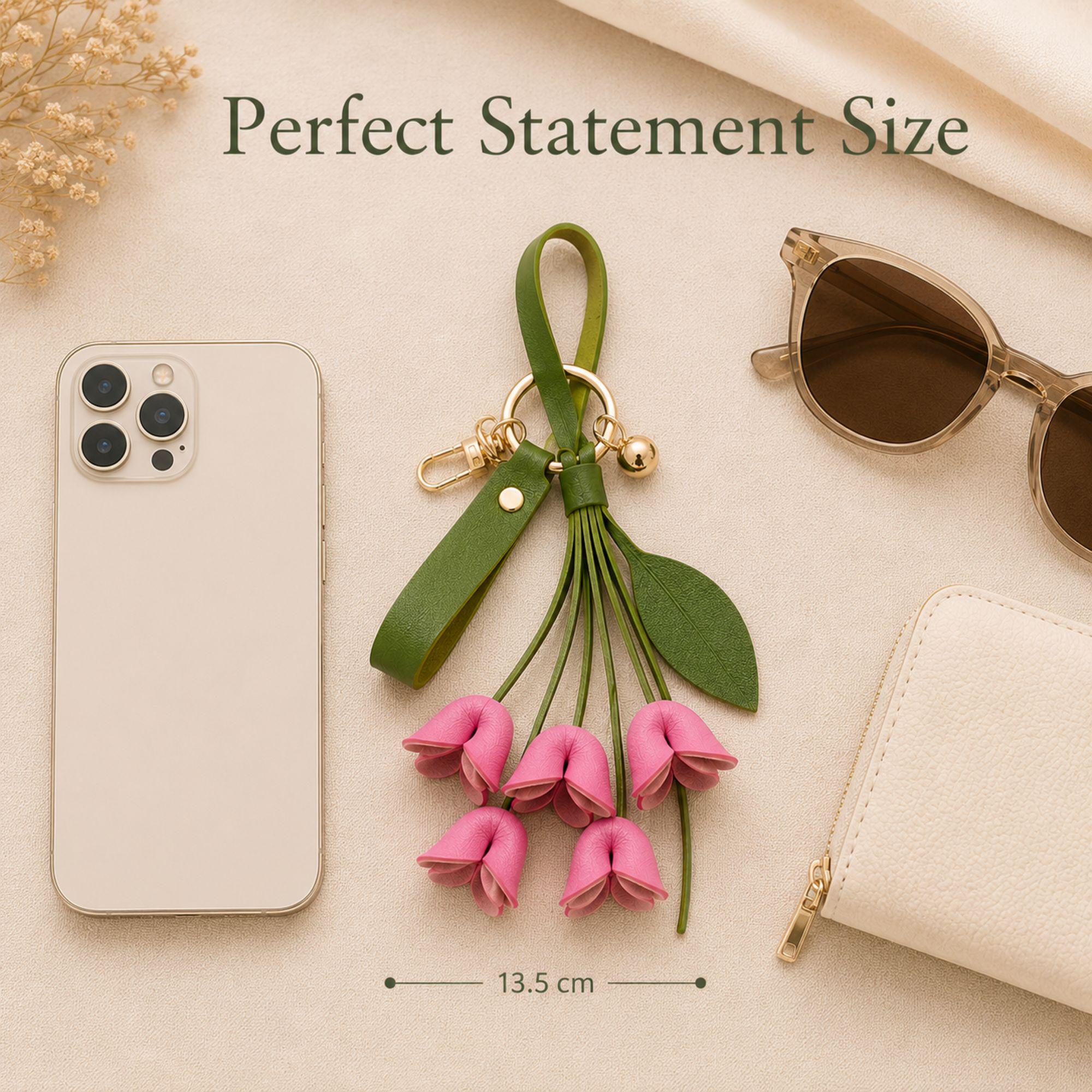 Rose Madder floral bag charm attached to luxury handbag featuring folded leather flowers, olive green leather strap, gold hardware, feminine purse accessory, trendy floral keychain, cute handbag charm, quiet luxury aesthetic, pink leather flower bag accessory, stylish purse charm for women, gift for her, luxury bag accessory, boutique fashion keychain, elegant floral purse accessory, Pinterest inspired handbag charm, soft feminine fashion accessory