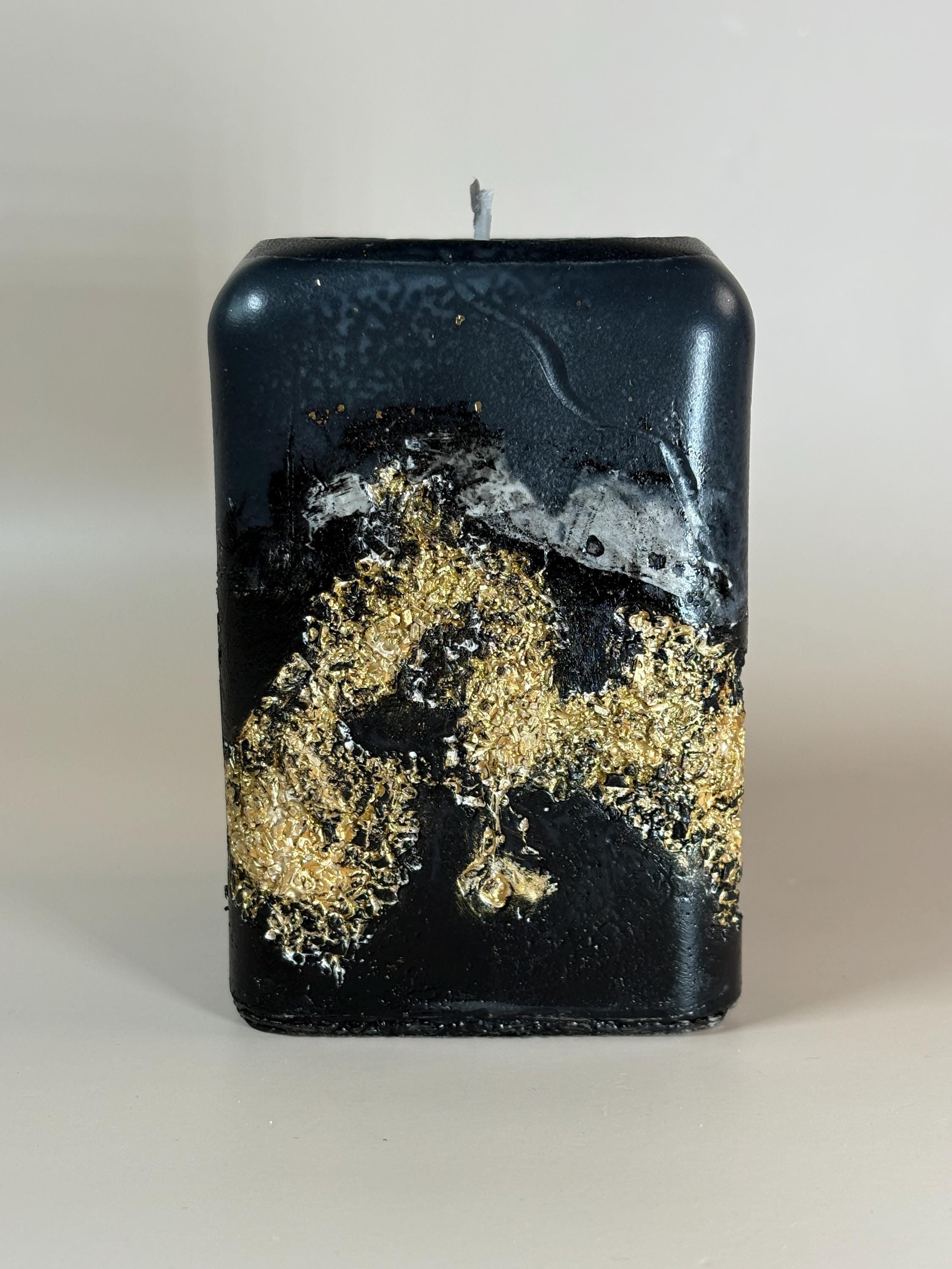 Luxury Black Decorative Candle with gold leaf detail, sculptural handmade style, modern home decor appeal, and elegant housewarming gift presentation.