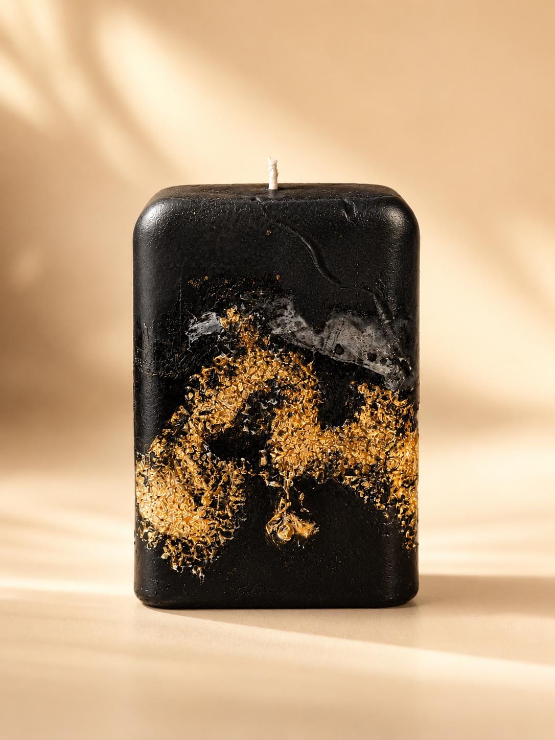 Luxury Black Decorative Candle with gold leaf detail, sculptural handmade style, modern home decor appeal, and elegant housewarming gift presentation.