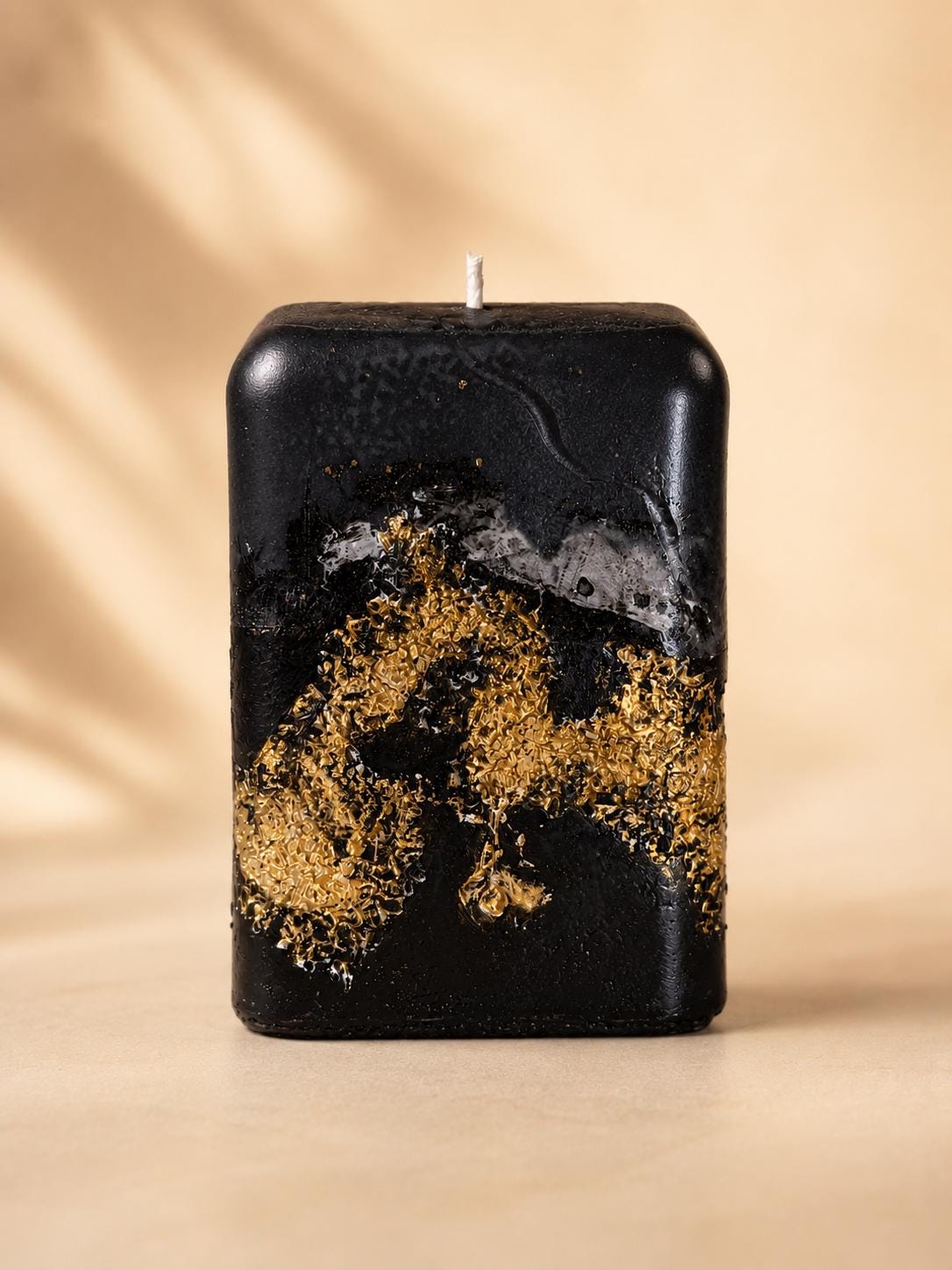 Luxury Black Decorative Candle with gold leaf detail, sculptural handmade style, modern home decor appeal, and elegant housewarming gift presentation.