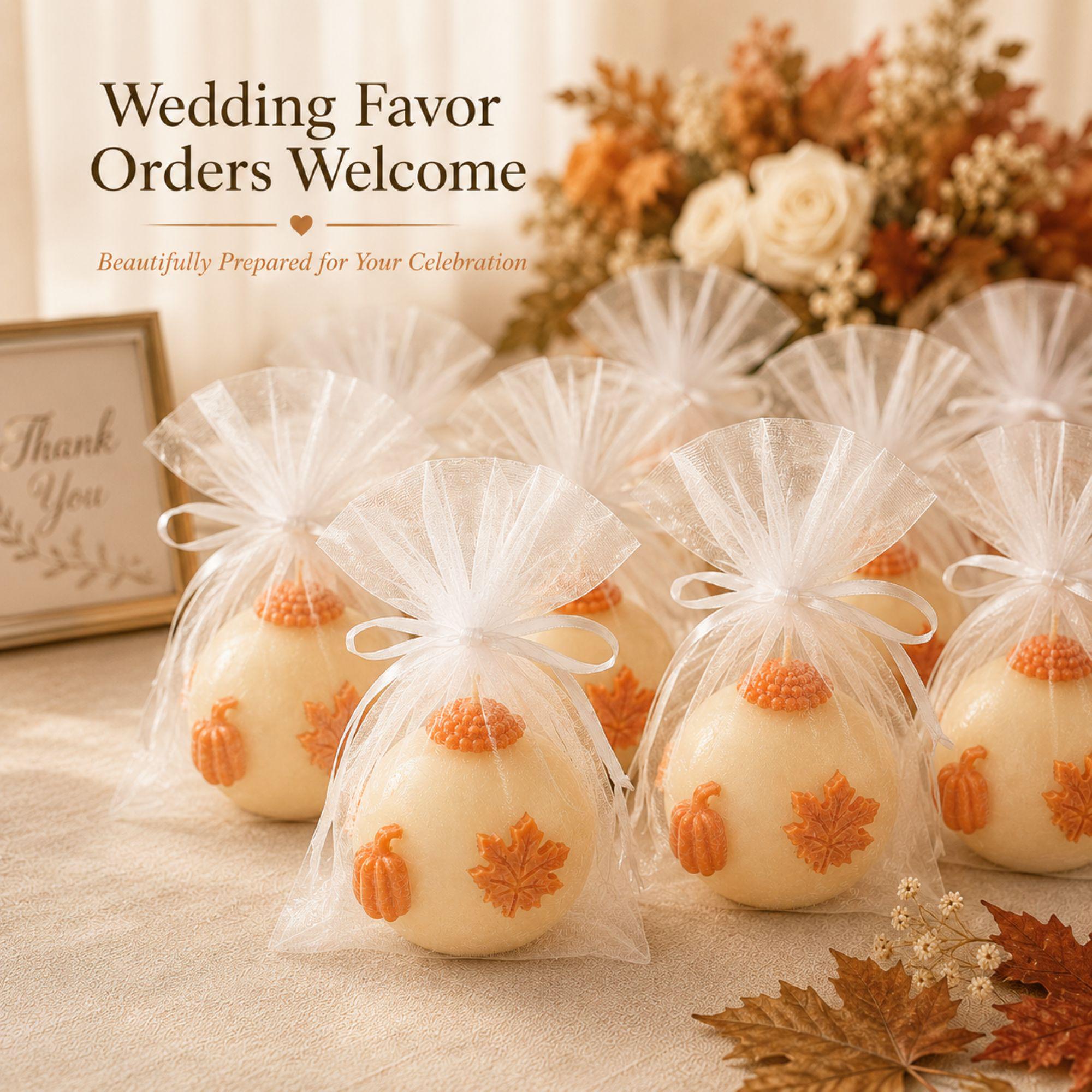 Handmade fall wedding favor featuring a 3 inch ivory sphere pumpkin candle with orange autumn maple leaf and pumpkin details, beautifully presented as a rustic wedding guest gift. Unique autumn wedding favor for October and November weddings, bridal showers, engagement parties, rehearsal dinners and fall celebrations. Individually wrapped in white organza for an elegant gift-ready presentation.