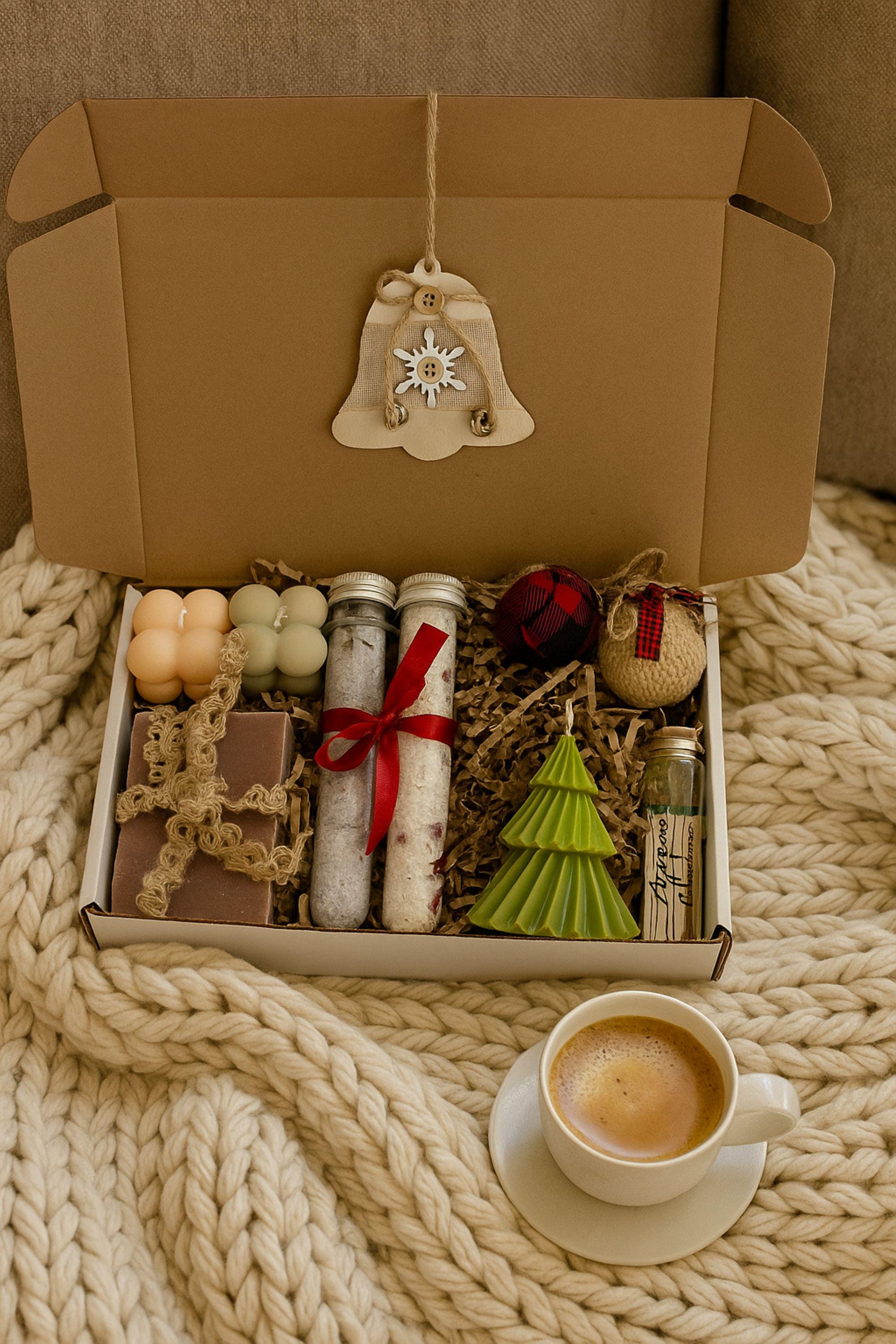 Open Christmas spa gift box with three bubble candles, two bath salts tubes, a green tree candle, rustic fabric ornaments, and a wooden Christmas tree decoration inside a kraft box with crinkle paper. Cozy holiday self-care set for women, handmade winter gift, small ready-to-gift Christmas box with candles, salts, and matchsticks.