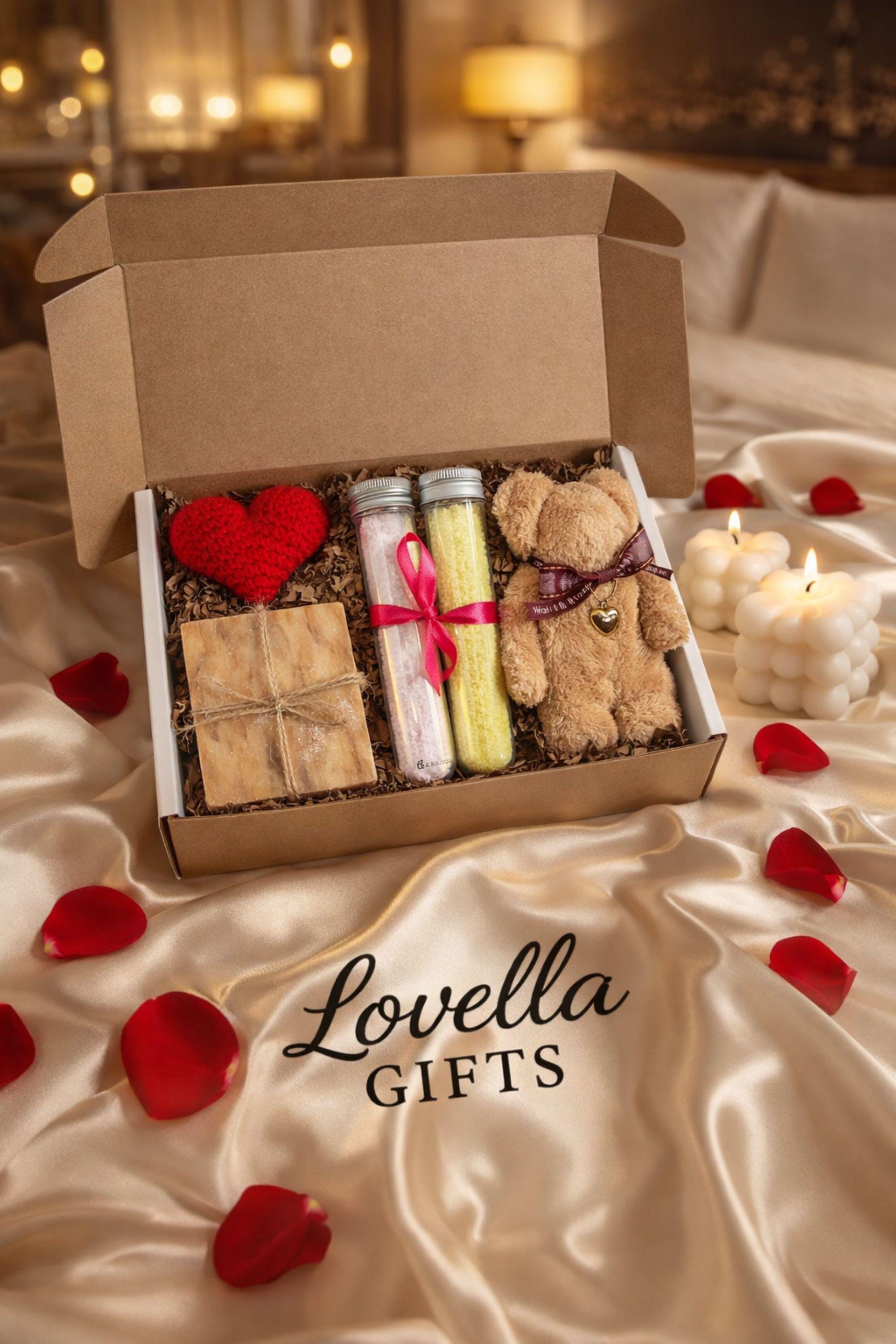 Comfort Valentine gift box featuring handmade bubble candles, artisan soap tied with twine, bath salts in glass tubes with ribbon, and a soft plush teddy bear with heart charm. Cozy thinking of you care package for her, perfect for long distance Valentine gifting, just because surprises, or sending comfort from afar. Handmade Valentine gift box arranged with shredded paper filler, ready to gift and ship directly to the recipient.