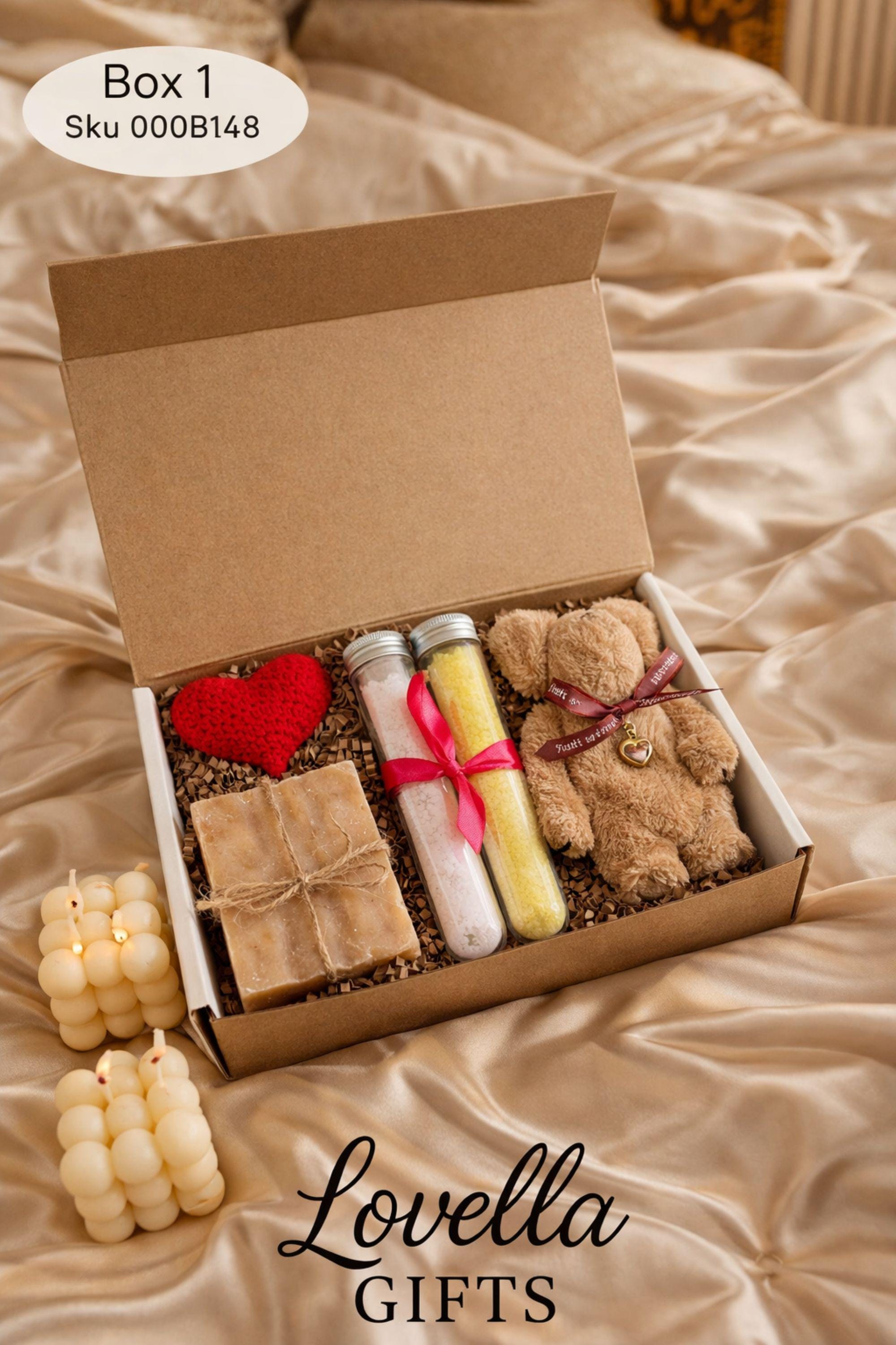 Comfort Valentine gift box featuring handmade bubble candles, artisan soap tied with twine, bath salts in glass tubes with ribbon, and a soft plush teddy bear with heart charm. Cozy thinking of you care package for her, perfect for long distance Valentine gifting, just because surprises, or sending comfort from afar. Handmade Valentine gift box arranged with shredded paper filler, ready to gift and ship directly to the recipient.