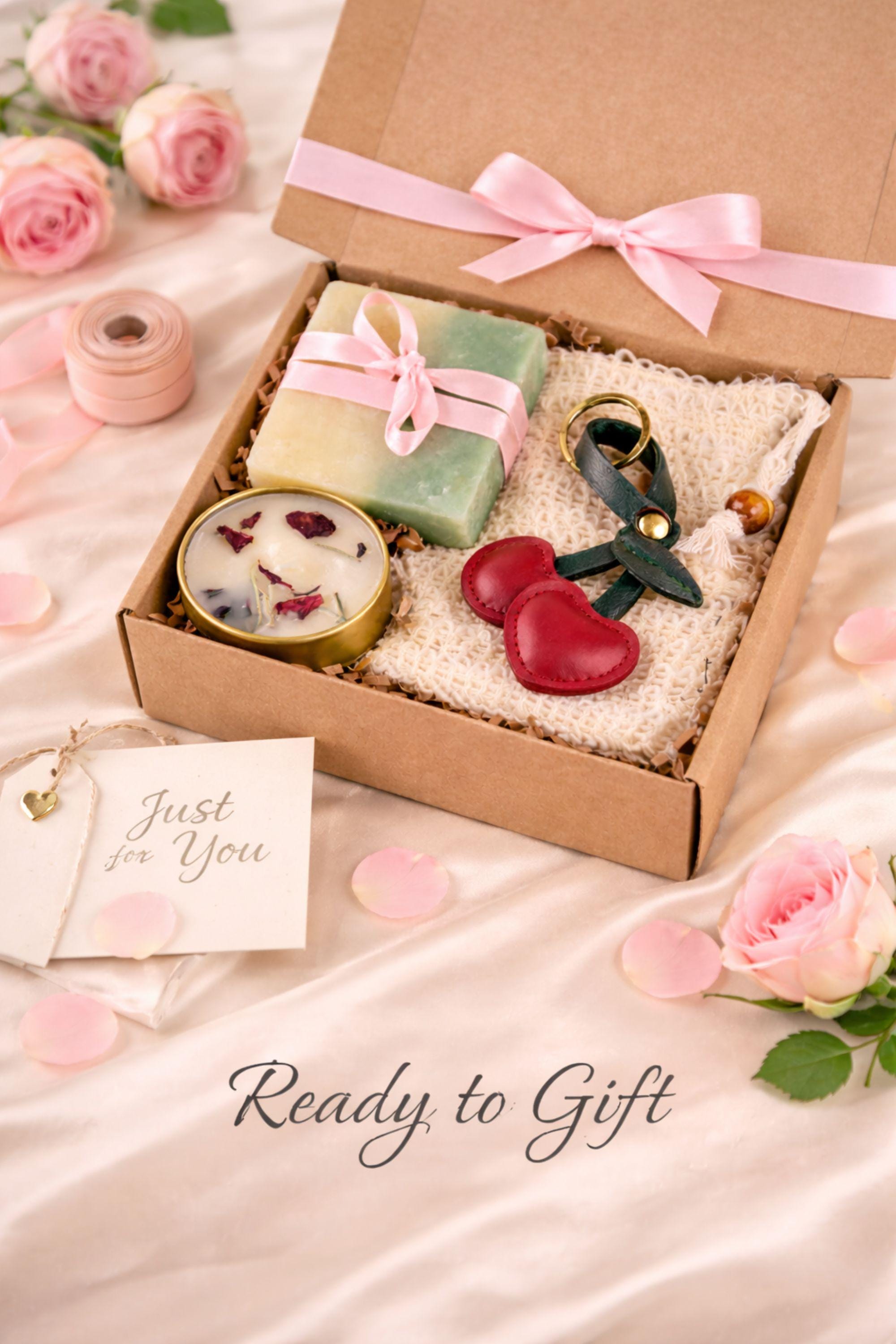 Cozy comfort gift box with handmade soap tied with red ribbon, natural candle in metal tin with dried petals, crocheted washcloth and leather cherry keychain arranged in a kraft box with eco filler. Thoughtful handmade care package perfect as a thinking of you gift, long distance gift, just because present or comforting cozy gift for her. Warm meaningful gift box designed to bring comfort, care and emotional warmth.