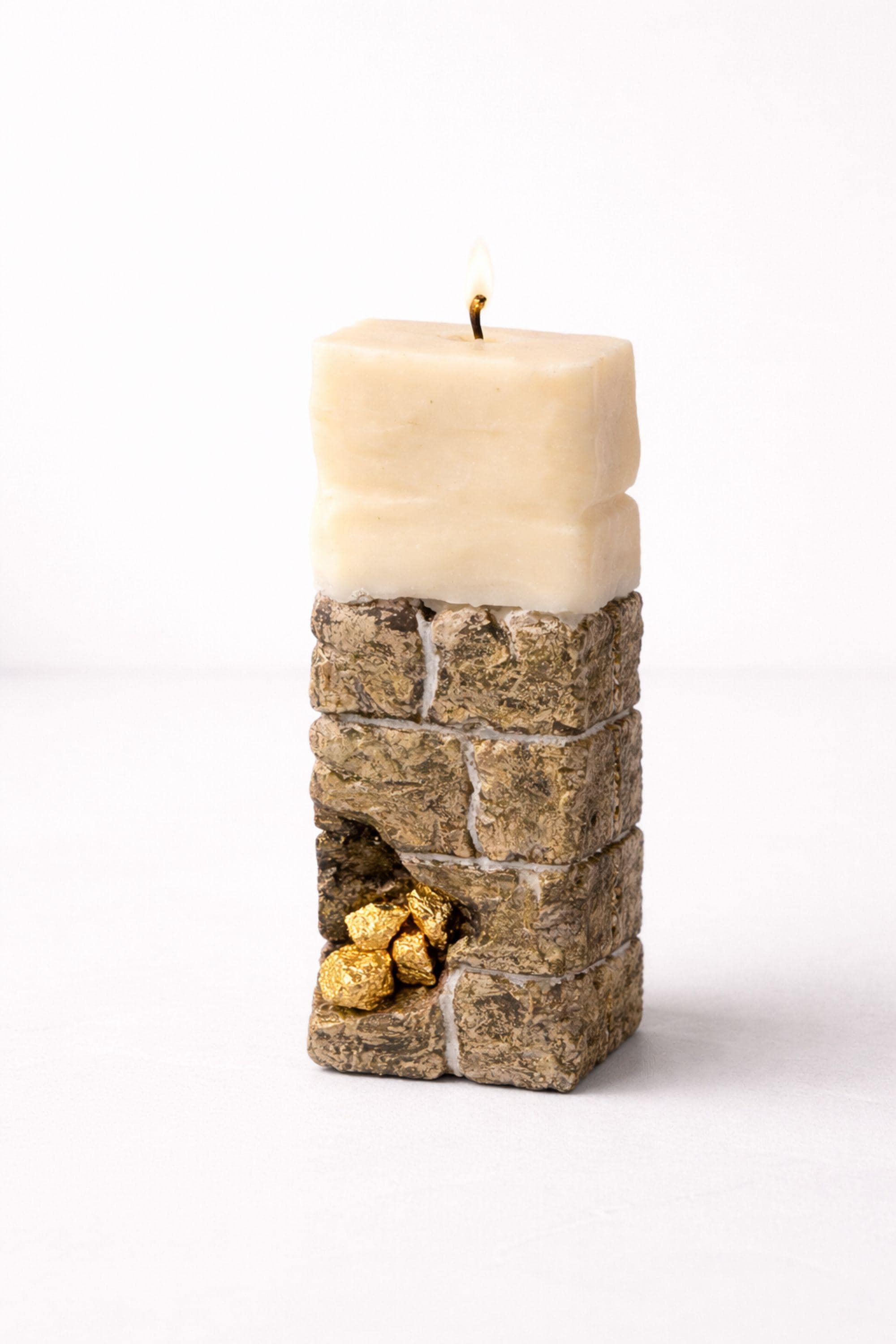 Minimalist sculptural candle decor with stone-inspired texture and gold detailing, perfect for modern home styling.