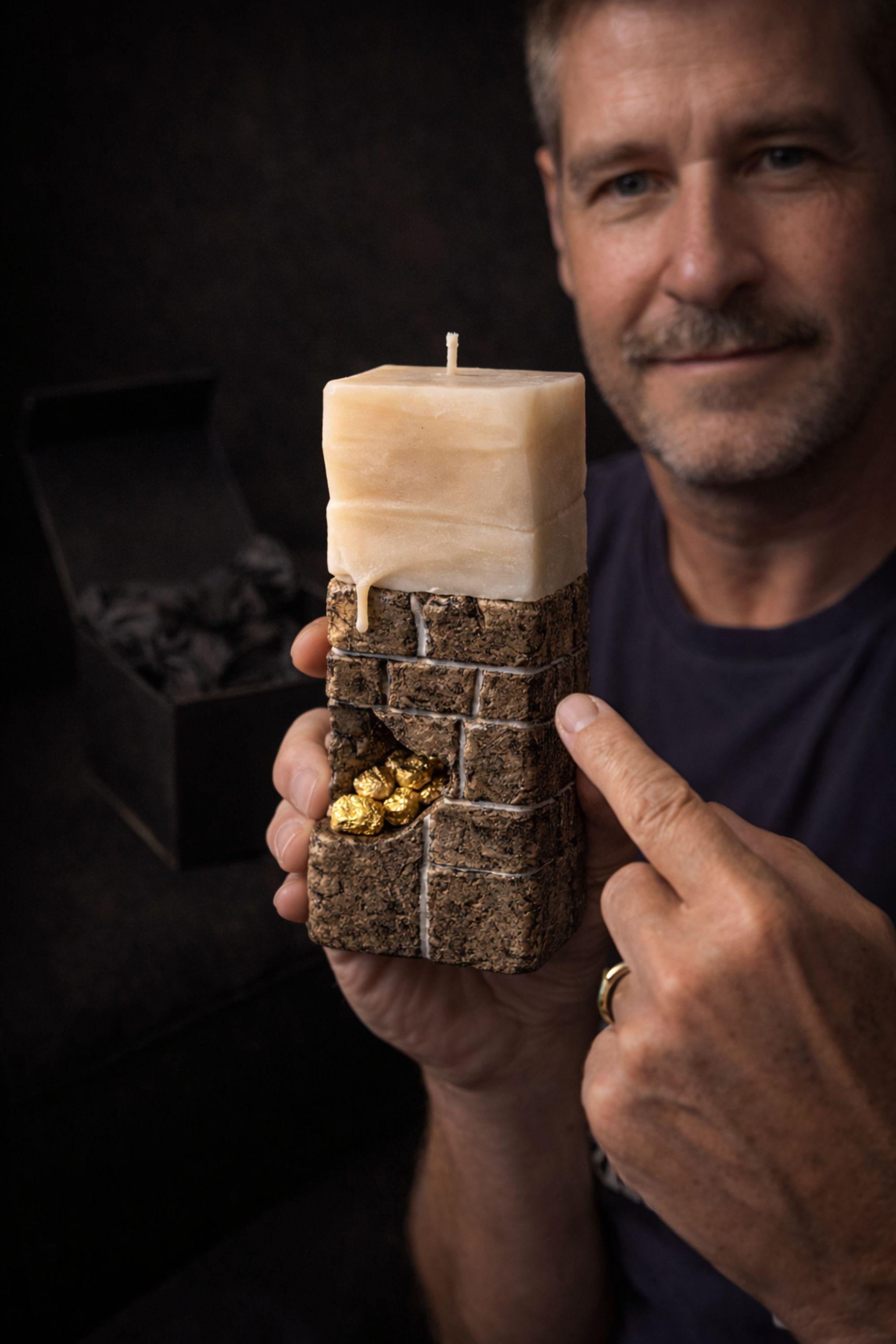 Dark sculptural candle designed as a bold statement decor object for modern interiors, featuring a stone inspired textured base, layered mineral form, and subtle 24 karat gold accents. This handmade wax art piece functions as both a functional candle and decorative sculpture, ideal for masculine home decor, minimalist styling, modern shelves, console tables, dramatic interior accents, luxury decor displays, and contemporary design focused spaces. One of a kind handmade object.