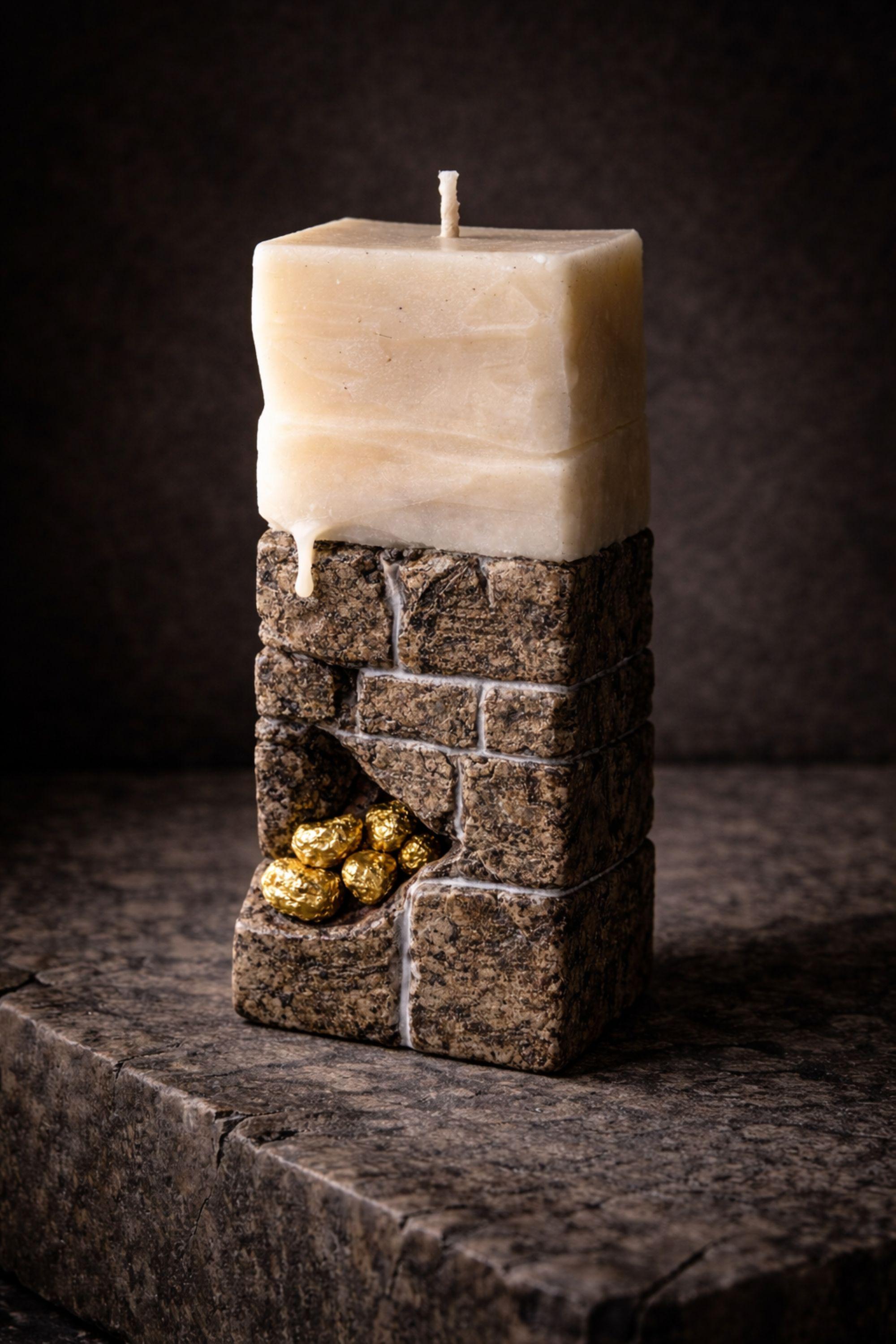 Sculptural candle decor with a stone-like texture and gold detail, perfect for modern interiors.