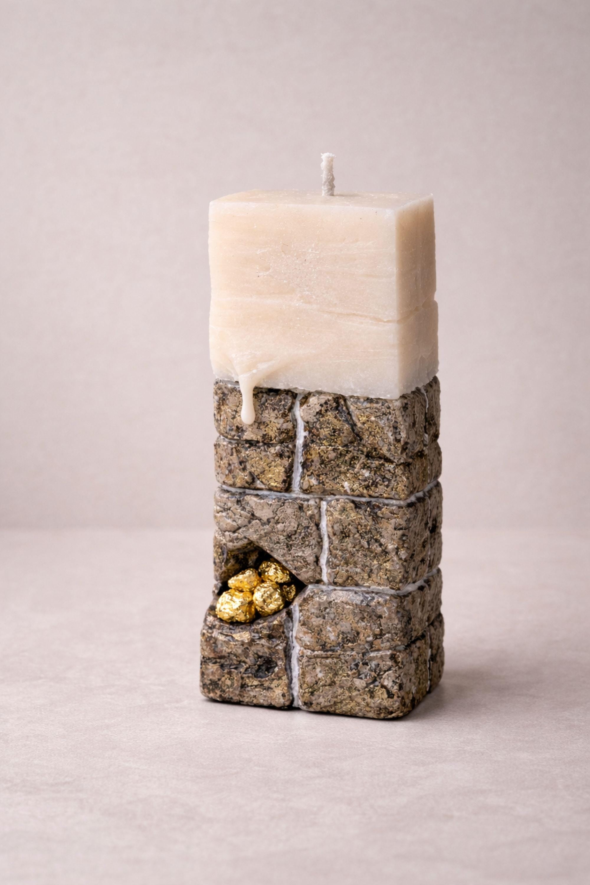 Luxury sculptural candle gift featuring unique stone-inspired design and gold detail, perfect for modern decor.