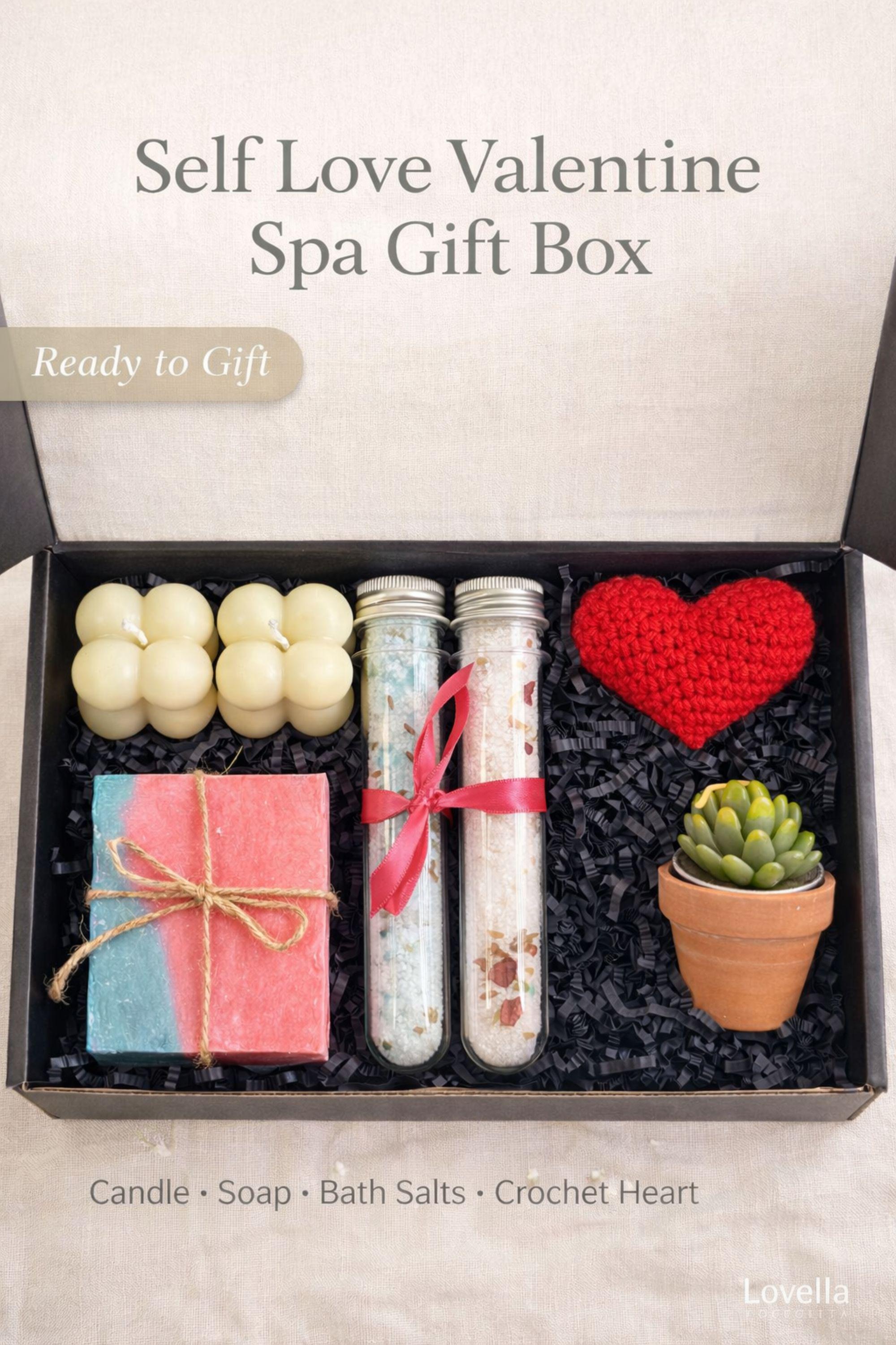 Self love Valentine spa gift box featuring two handmade bubble candles, artisan soap tied with twine, bath salts in glass tubes with ribbon, a crochet heart, and a decorative succulent in a gift box with shredded paper filler. Neutral and calming self care gift for women, ready to gift for Valentine’s Day, self love, thinking of you, or just because occasions. Handmade spa gift with cozy aesthetic.