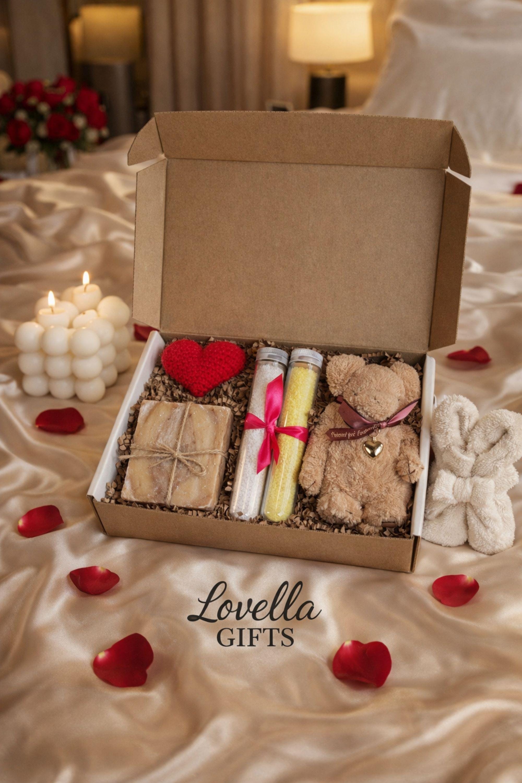 Comfort Valentine gift box featuring handmade bubble candles, artisan soap tied with twine, bath salts in glass tubes with ribbon, and a soft plush teddy bear with heart charm. Cozy thinking of you care package for her, perfect for long distance Valentine gifting, just because surprises, or sending comfort from afar. Handmade Valentine gift box arranged with shredded paper filler, ready to gift and ship directly to the recipient.