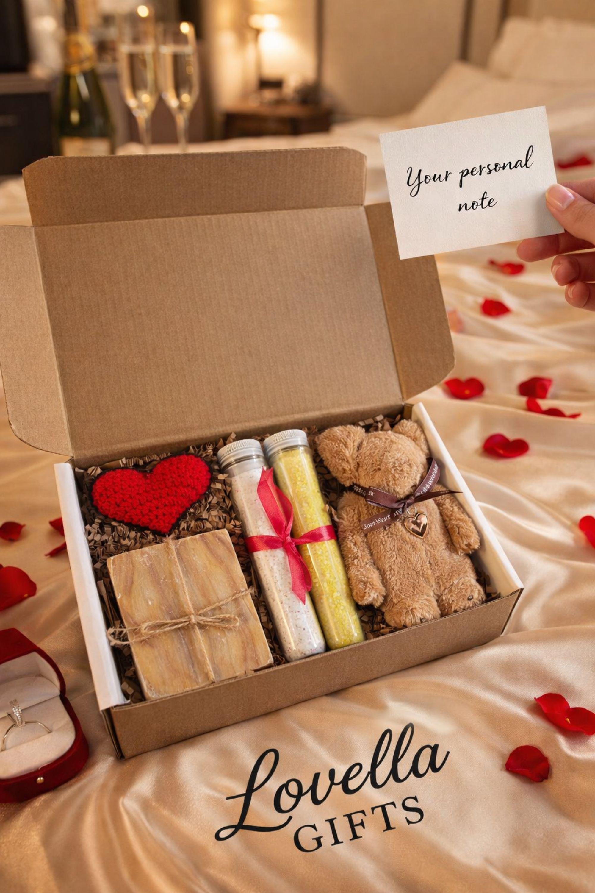 Comfort Valentine gift box featuring handmade bubble candles, artisan soap tied with twine, bath salts in glass tubes with ribbon, and a soft plush teddy bear with heart charm. Cozy thinking of you care package for her, perfect for long distance Valentine gifting, just because surprises, or sending comfort from afar. Handmade Valentine gift box arranged with shredded paper filler, ready to gift and ship directly to the recipient.