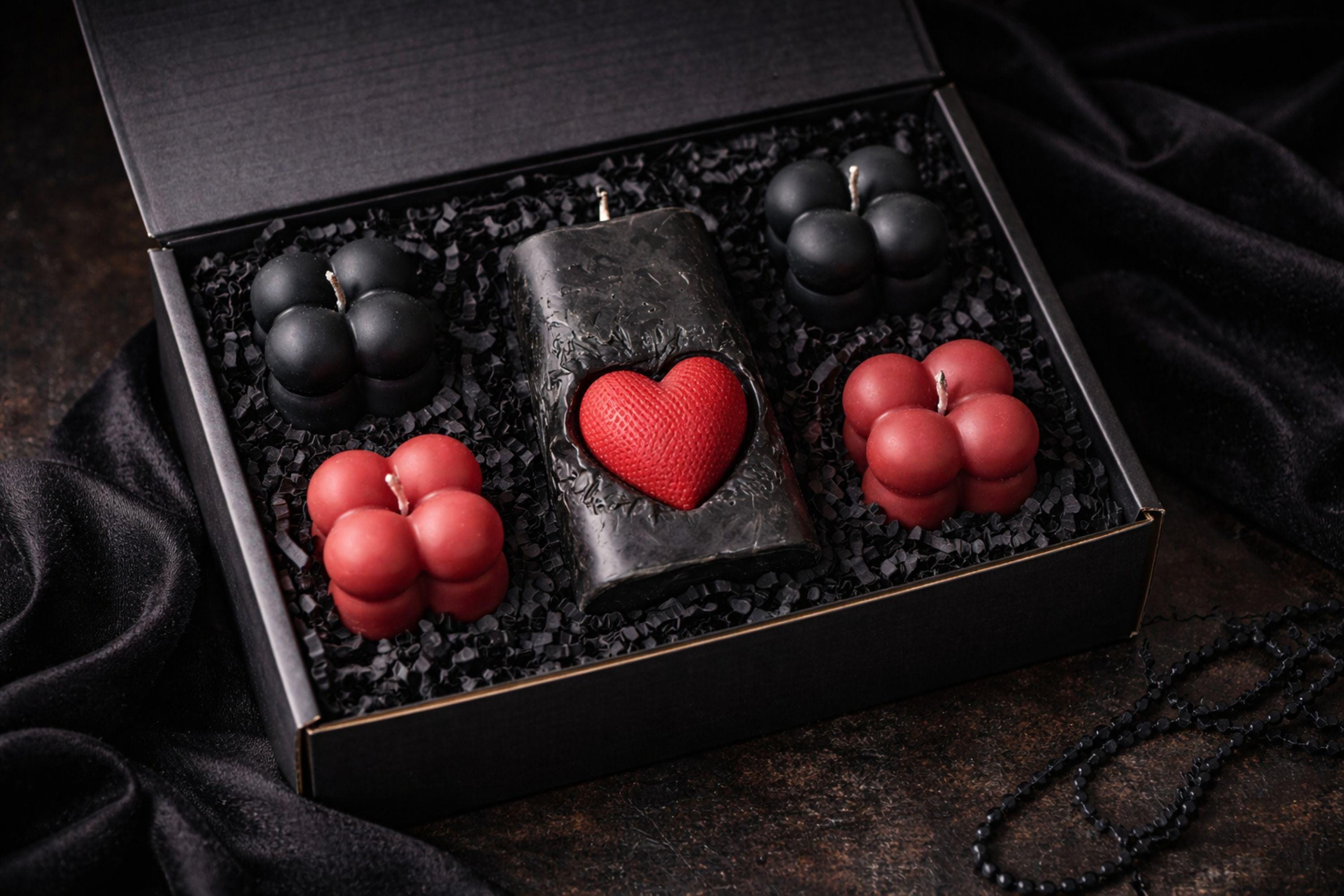 Gothic Sacred Heart Ritual Box featuring a handcrafted black candle with a red heart centerpiece and black and red bubble candles arranged in a dark gift box. This dark ritual candle set is designed for gothic home decor, witchy interiors, and alternative spiritual gifts. Unique handmade candle box with dramatic dark aesthetic, perfect for altar decor, shelves, or intentional spaces.