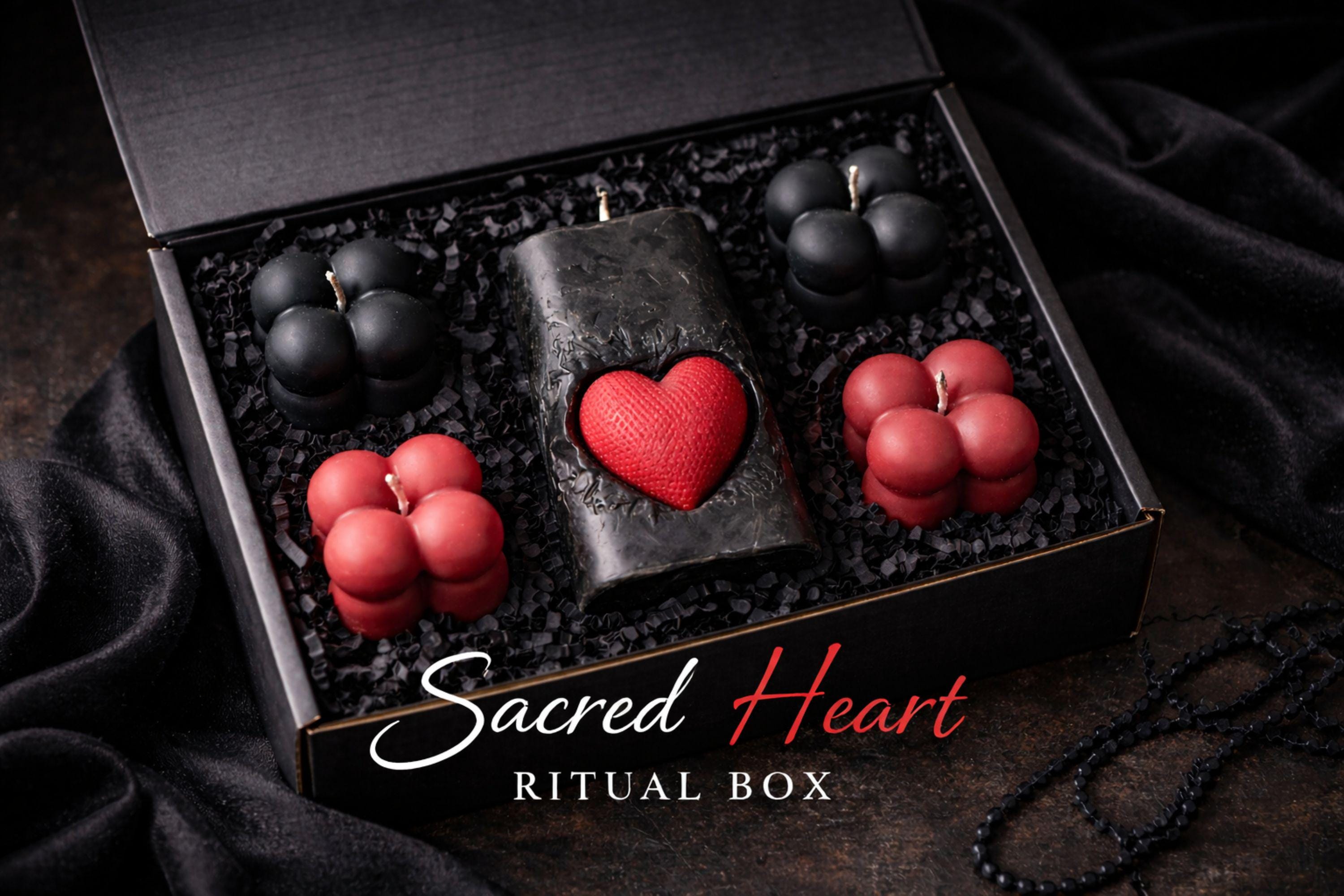 Gothic Sacred Heart Ritual Box featuring a handcrafted black candle with a red heart centerpiece and black and red bubble candles arranged in a dark gift box. This dark ritual candle set is designed for gothic home decor, witchy interiors, and alternative spiritual gifts. Unique handmade candle box with dramatic dark aesthetic, perfect for altar decor, shelves, or intentional spaces.