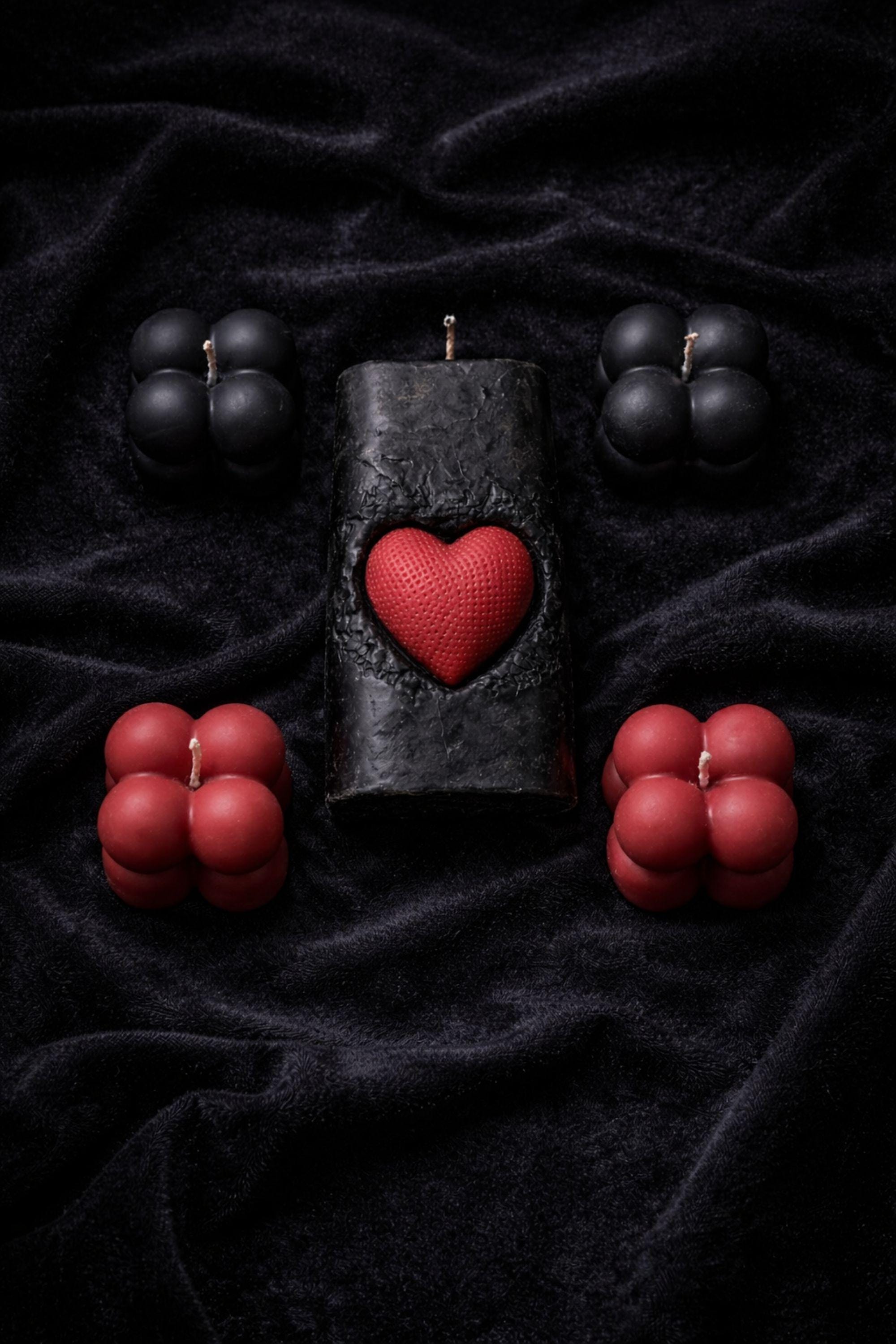 Gothic Sacred Heart Ritual Box featuring a handcrafted black candle with a red heart centerpiece and black and red bubble candles arranged in a dark gift box. This dark ritual candle set is designed for gothic home decor, witchy interiors, and alternative spiritual gifts. Unique handmade candle box with dramatic dark aesthetic, perfect for altar decor, shelves, or intentional spaces.