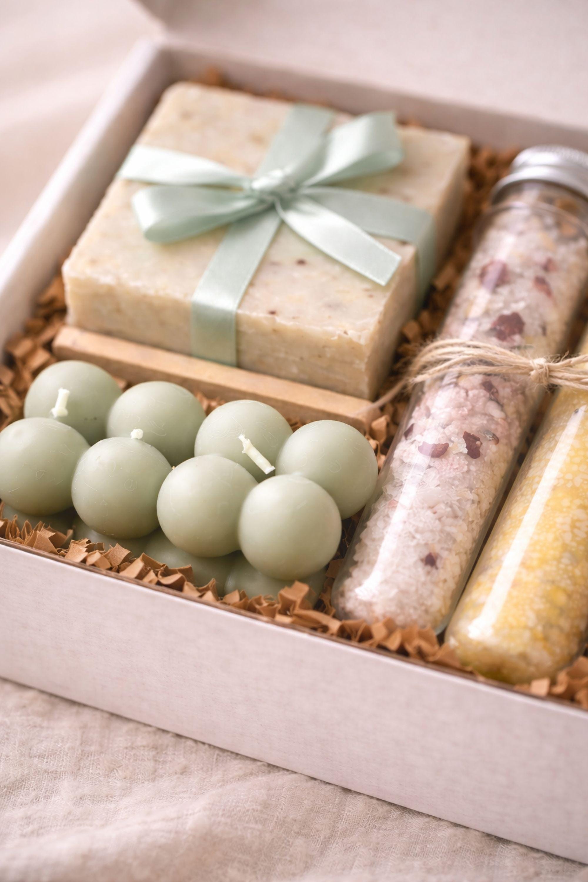 Close-up view of sage green bubble candle texture, handmade soap surface with ribbon, and natural paper filler inside a minimalist gift box. Handmade candle and soap set highlighting soft materials and calm tones, created for cozy home rituals, everyday self care routines, and simple slow living moments with a neutral, minimalist aesthetic.
