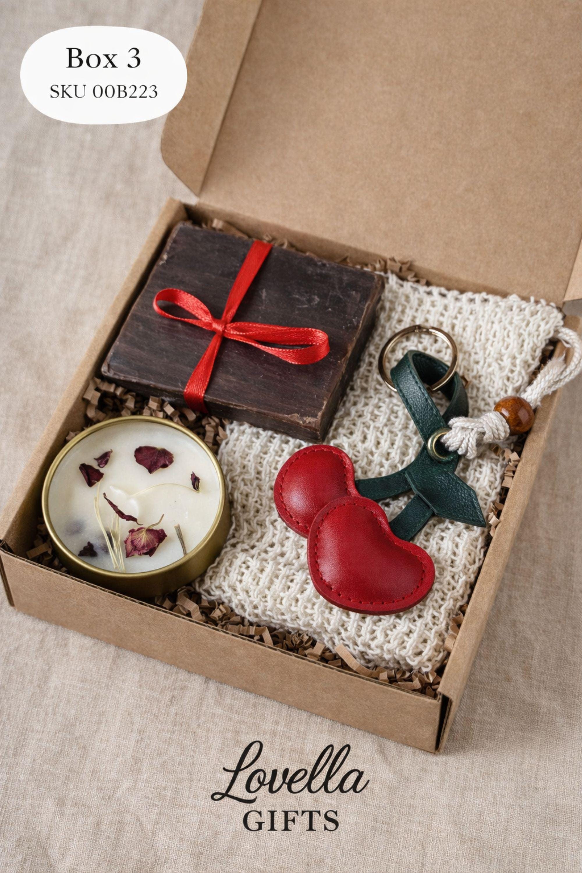 Romantic handmade gift box for her displayed open in a kraft box with a red heart candle, natural soap tied with a red ribbon, and two glass tubes filled with bath salts. This thoughtful love gift features warm red accents and handcrafted details, presented on a clean neutral background. A romantic gift set designed to express love in a simple, elegant way, perfect as a romantic gift for her, anniversary present, or heartfelt love surprise.
