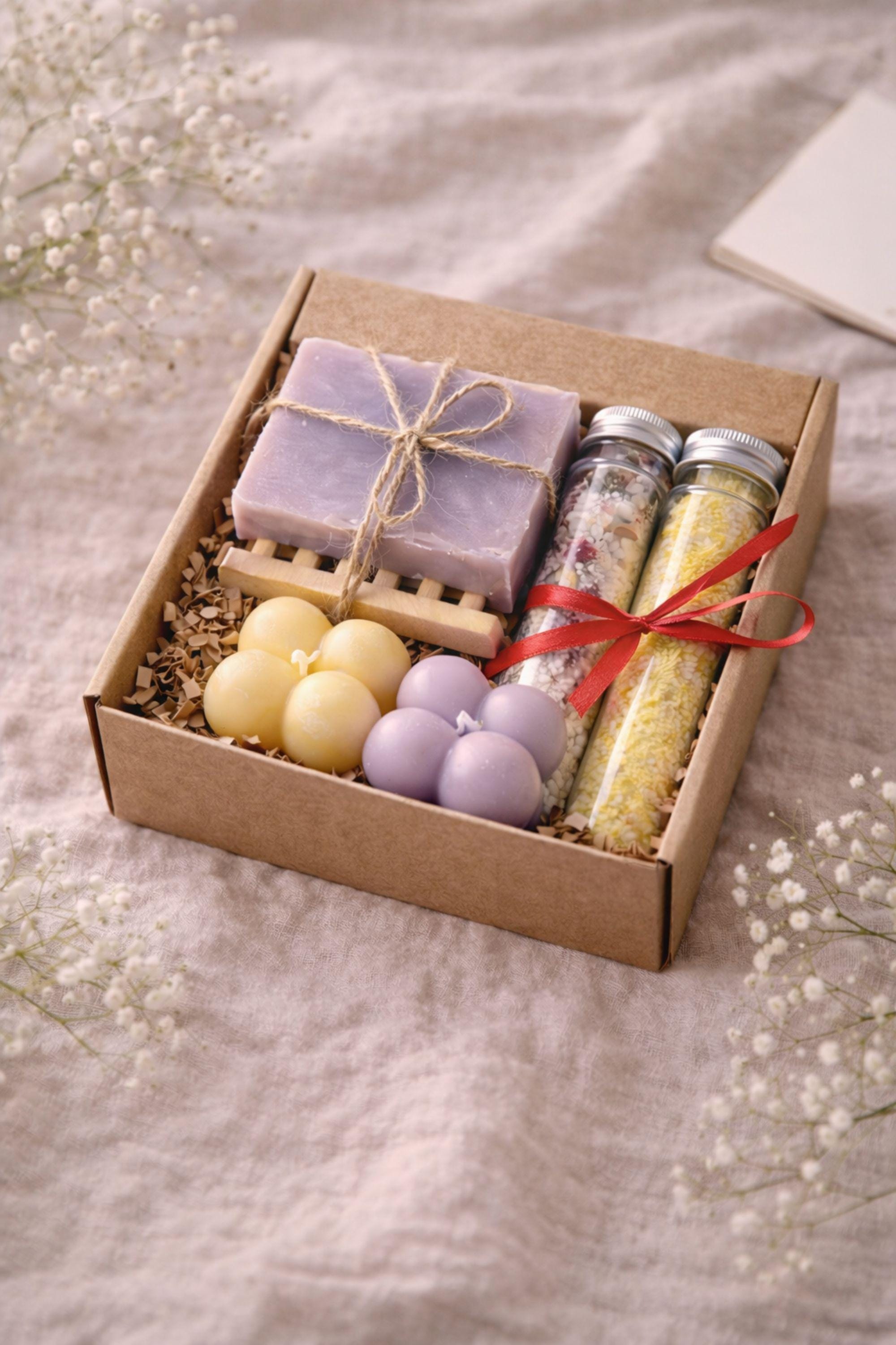 Open handmade gift box for mom displayed on a neutral surface, showing a cozy arrangement of colorful bubble candles, natural soap tied with twine, and two glass tubes of bath salts inside a small 6x6 inch kraft box. Thoughtful gift for mom featuring warm colors and handmade details, designed as a cozy, ready-to-gift present for birthdays, appreciation, or everyday gifting.