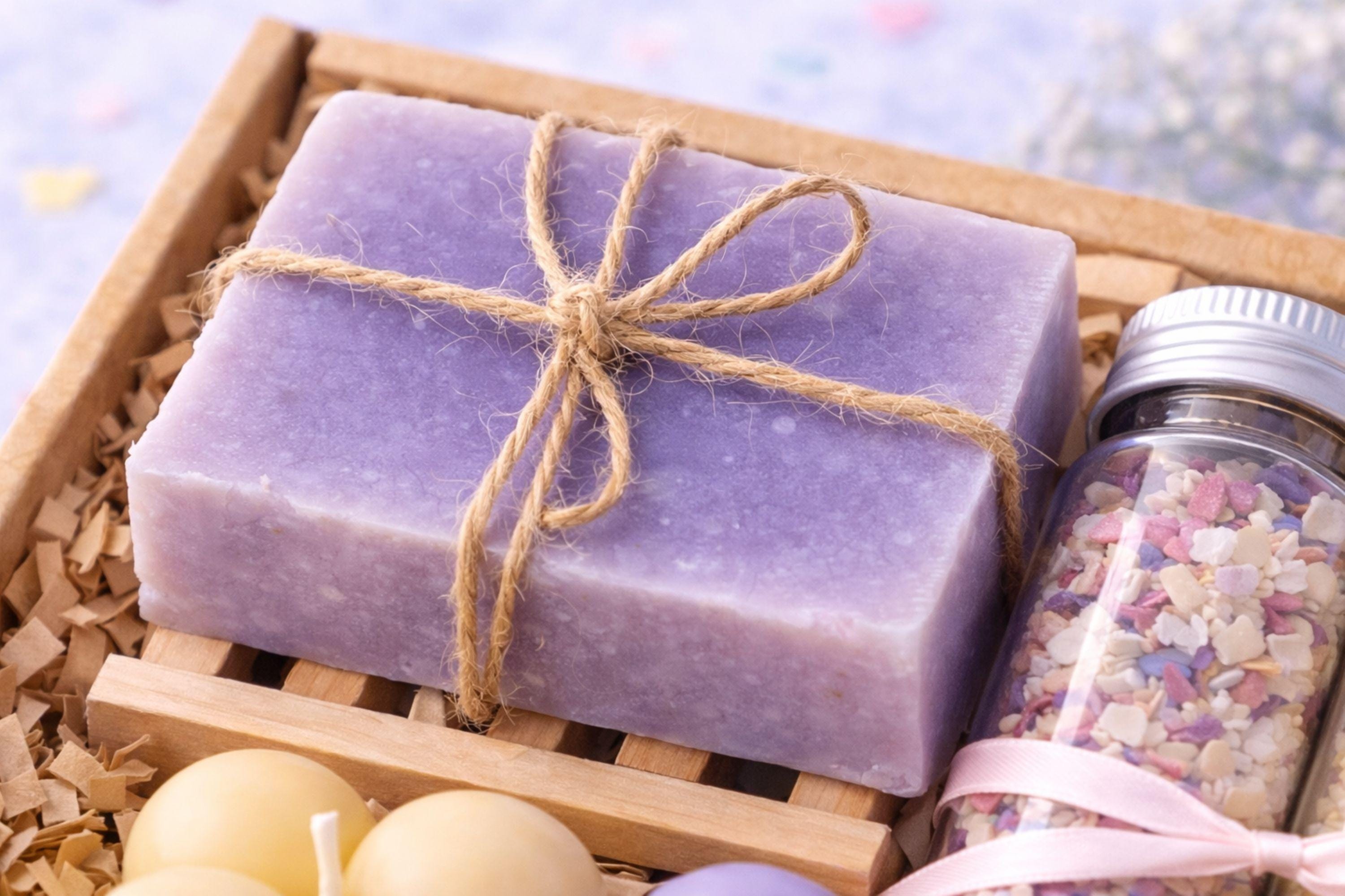 Close-up photograph of natural handmade soap tied with rustic twine, showing texture and smooth surface details. Soap is part of a handmade gift box for best friend, highlighting small-batch craftsmanship and playful yet cozy aesthetic suitable for fun everyday gifting.