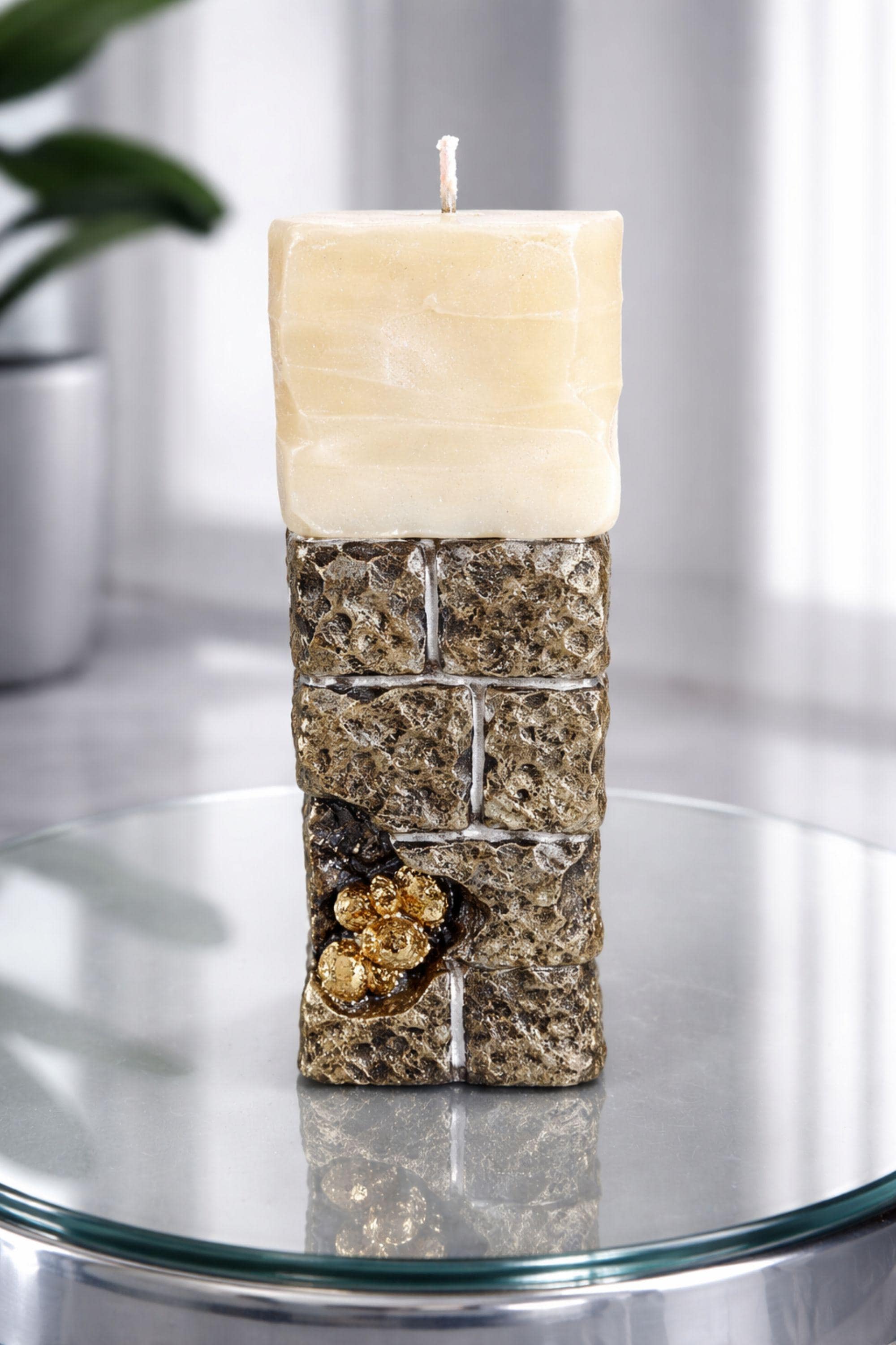 Sculptural ritual candle handmade from wax with textured stone-inspired surface and metallic gold detailing, designed as a modern altar decor object. Minimalist sculptural candle that can be displayed as art or burned intentionally. Artisan wax sculpture candle for ritual space, meditation altar, or modern interior decor. Unique handcrafted statement candle with raw texture and architectural form, photographed on neutral background.