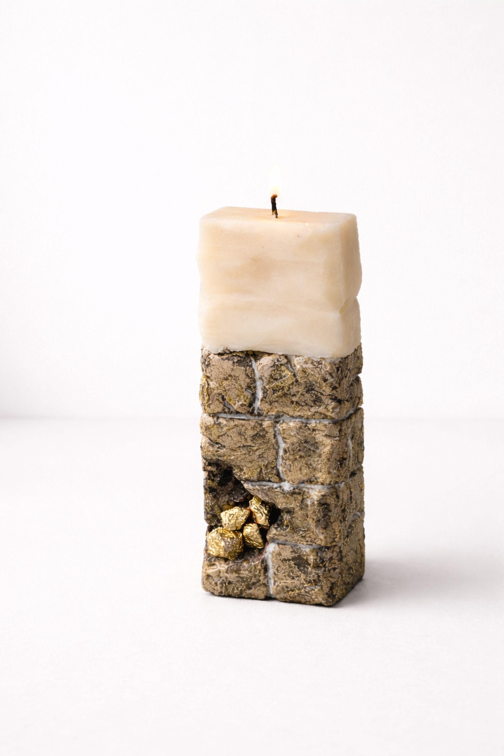 Minimalist sculptural candle decor with stone-inspired texture and gold detailing, serving as luxury handmade art.