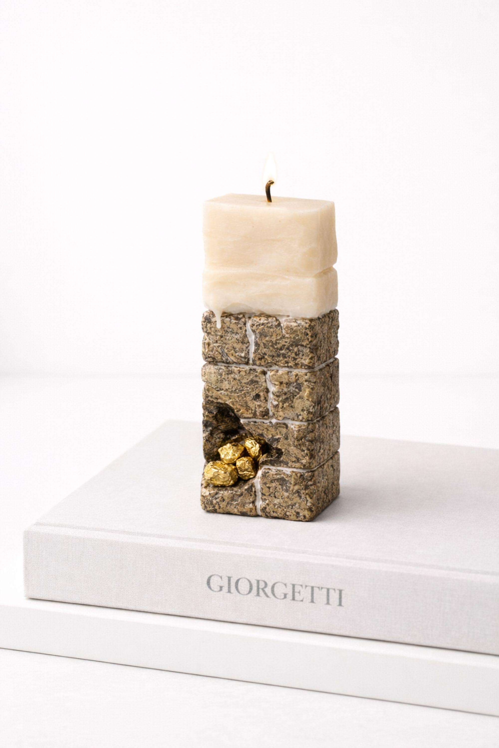 Minimalist sculptural candle decor on a stylish book, showcasing its modern design and luxurious texture.