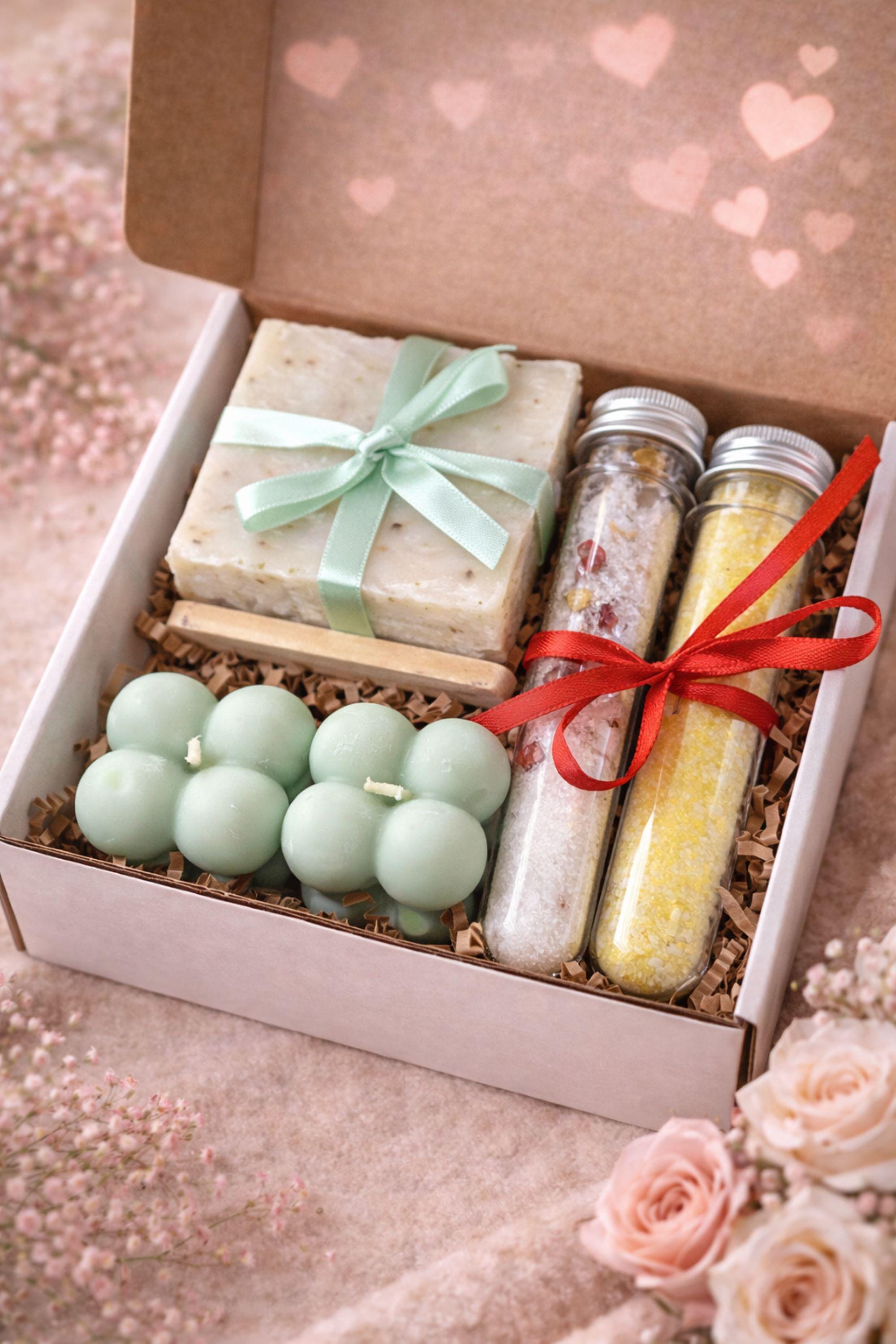 Valentine gift box for her displayed open in a kraft box, featuring handmade sage bubble candles, natural soap tied with a soft ribbon, and two glass tubes of bath salts arranged neatly with filler. Calm Valentine care package designed in soothing green and neutral tones, perfect as a gentle handmade Valentine gift, comfort box, or thoughtful alternative to traditional romantic presents.