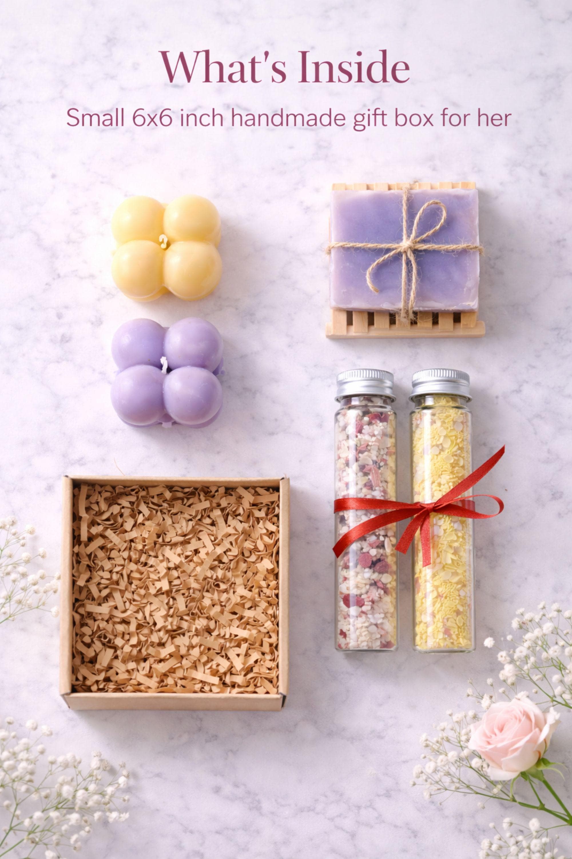 Close-up photograph showing handmade bubble candles in soft pastel tones, natural soap with twine wrap, and bath salts in glass tubes. Detailed view highlighting small batch craftsmanship and textures inside a handmade gift box for her, emphasizing quality, warmth, and careful presentation.
