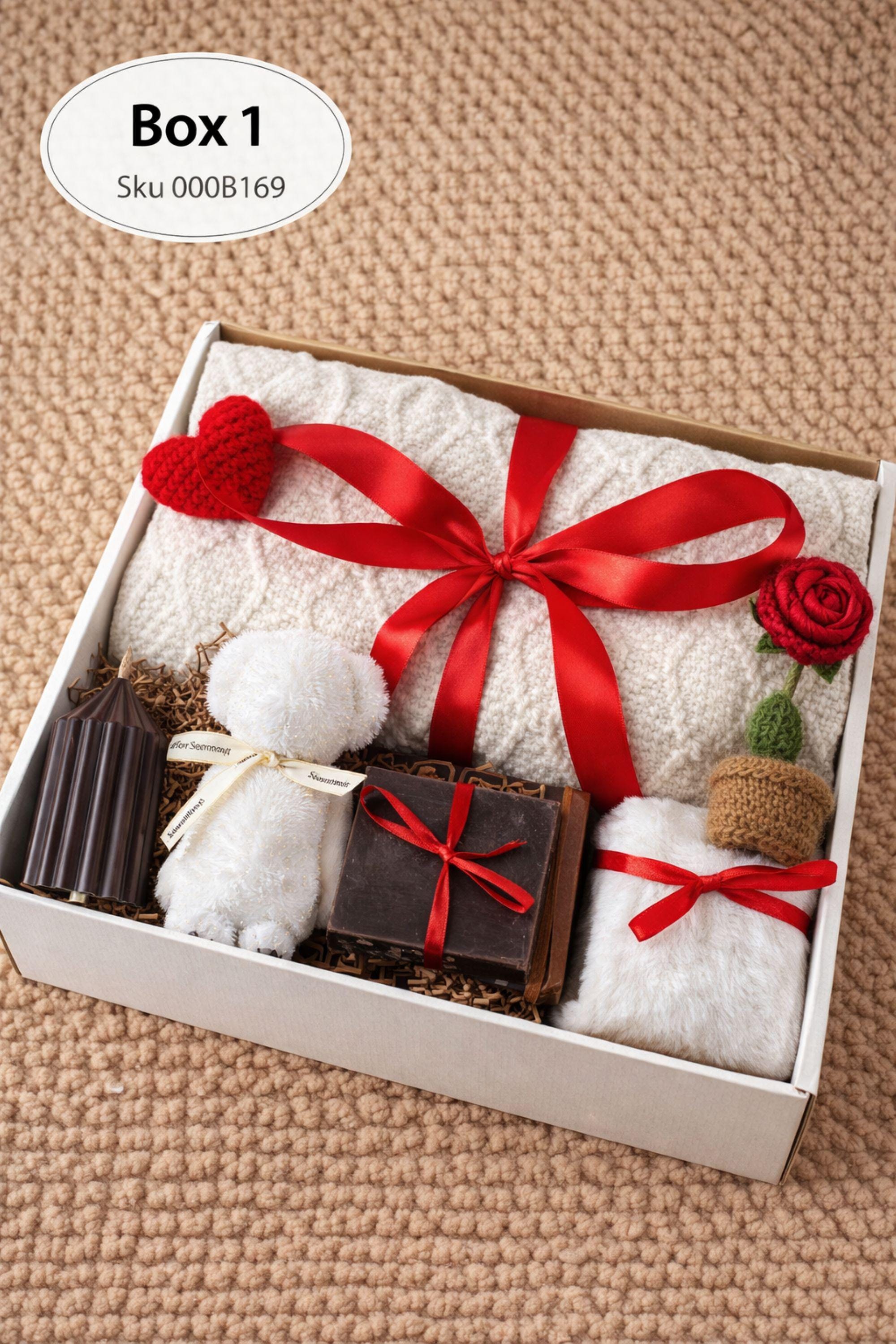 Large cozy blanket gift box with handmade candles, soap, plush socks, and soft bear-shaped face cloth arranged in a white gift box. A rolled cream blanket tied with red ribbon sits at the back, paired with a heart candle, pillar candle, artisan soap, crochet heart and flower, and cozy accessories. A warm self care comfort gift ideal for Valentine’s Day, birthdays, or sending love and relaxation.