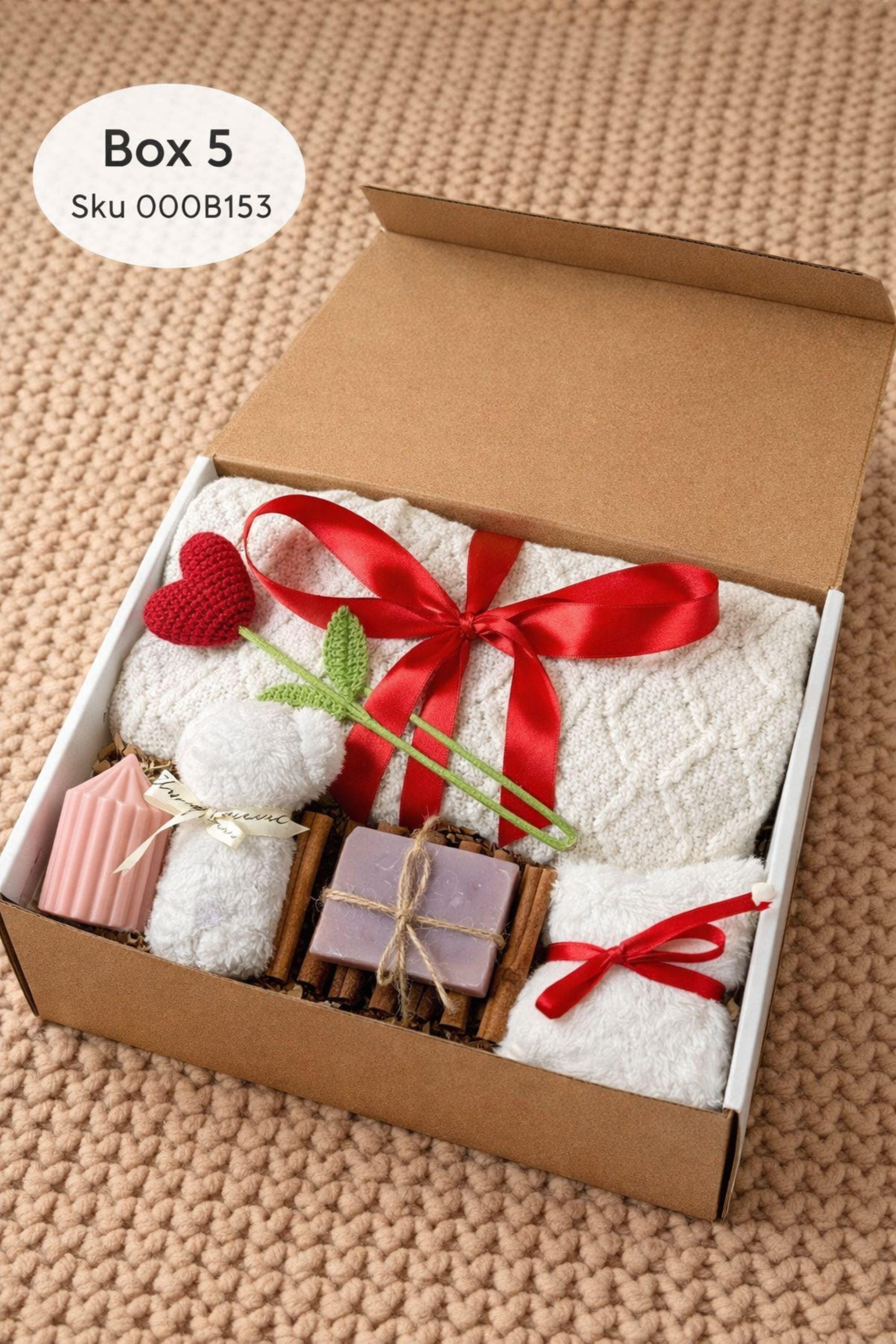 Large cozy blanket gift box with handmade candles, soap, plush socks, and soft bear-shaped face cloth arranged in a white gift box. A rolled cream blanket tied with red ribbon sits at the back, paired with a heart candle, pillar candle, artisan soap, crochet heart and flower, and cozy accessories. A warm self care comfort gift ideal for Valentine’s Day, birthdays, or sending love and relaxation.