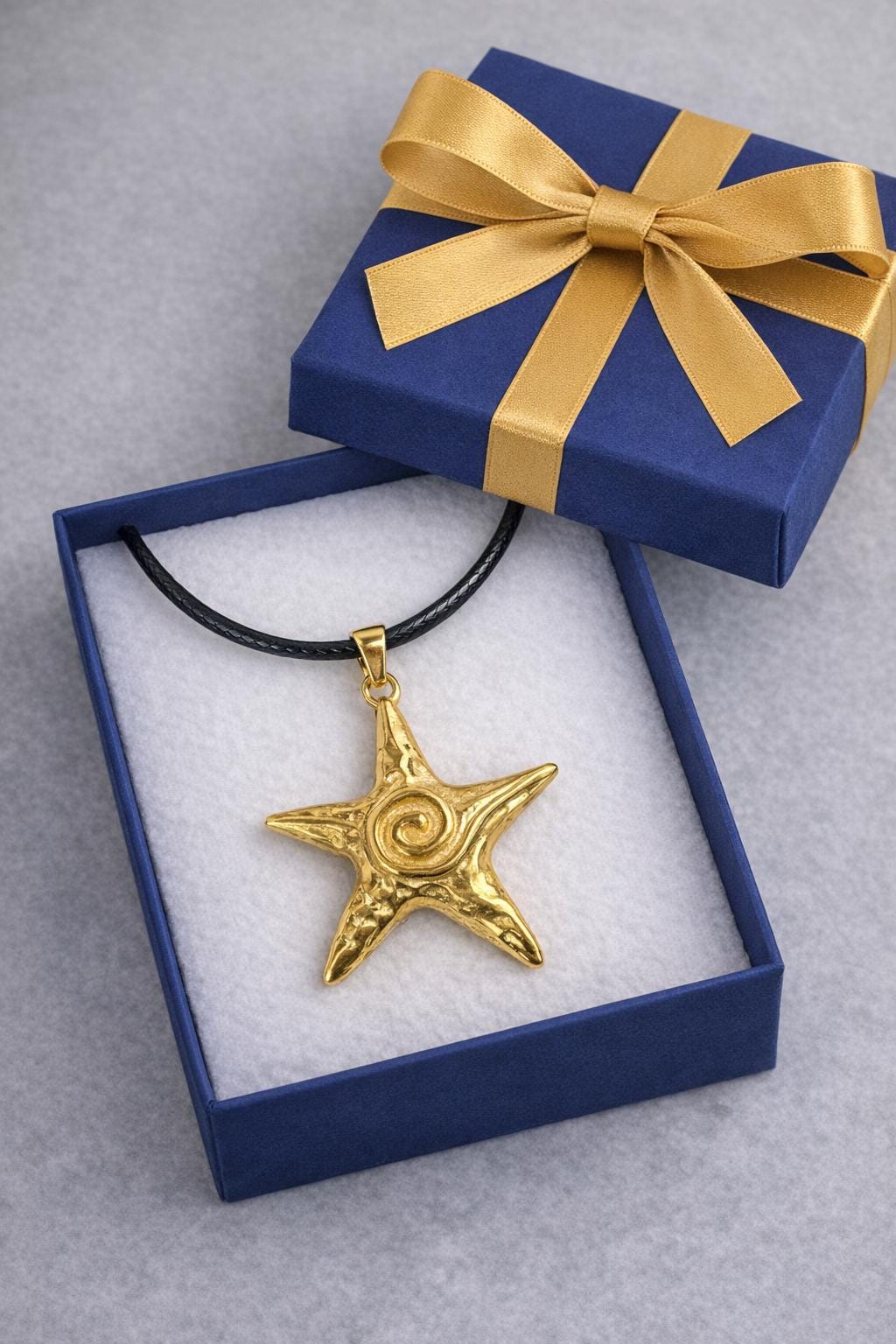 Coastal Star Necklace on a black cord with a textured sea star pendant.