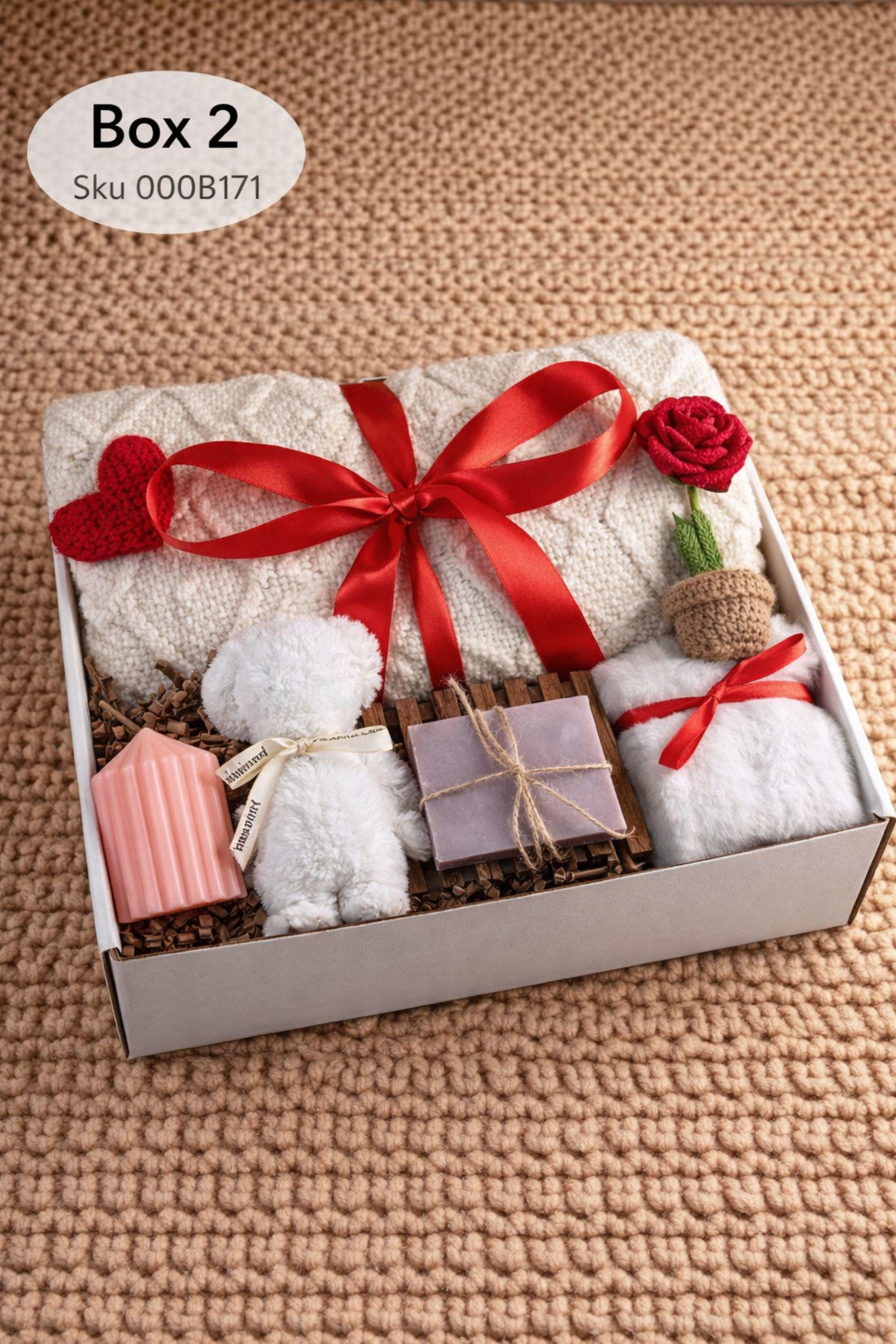 Large cozy blanket gift box with handmade candles, soap, plush socks, and soft bear-shaped face cloth arranged in a white gift box. A rolled cream blanket tied with red ribbon sits at the back, paired with a heart candle, pillar candle, artisan soap, crochet heart and flower, and cozy accessories. A warm self care comfort gift ideal for Valentine’s Day, birthdays, or sending love and relaxation.