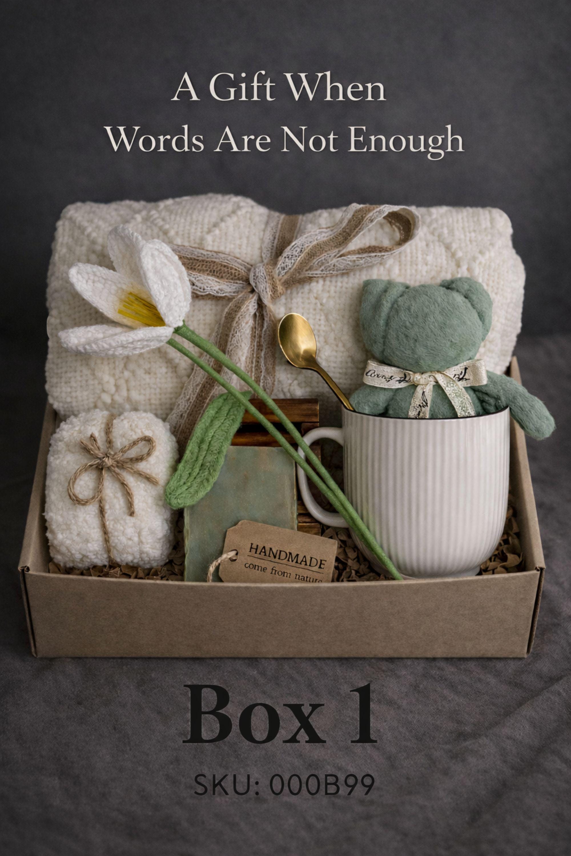 Sympathy gift box for loss of loved one featuring a cozy knit blanket, handmade soap, ceramic mug with teddy bear, rolled towel, and gold spoon arranged inside a kraft box on a dark neutral background. This bereavement care package is designed as a grief support gift and condolence gift box, offering comfort during difficult times. A thoughtful memorial gift idea to send love and support when words are not enough.