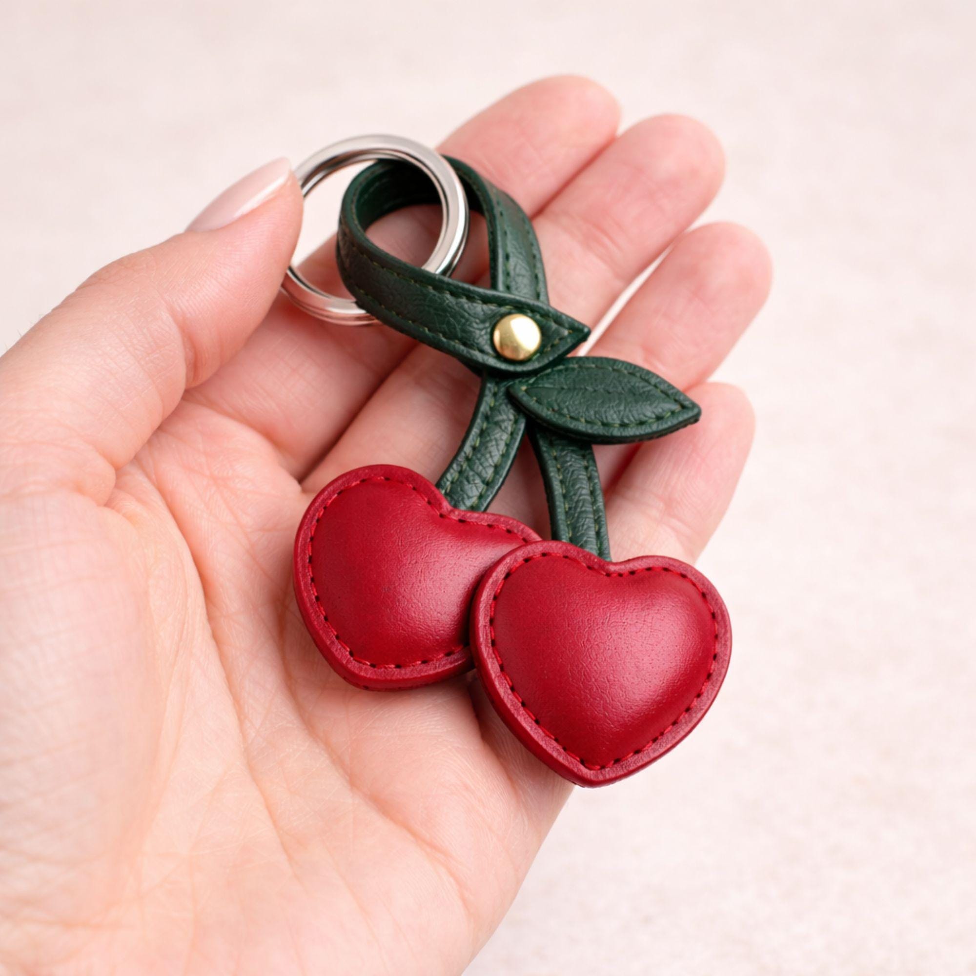 Cherry keychain add on placed inside neutral gift box with kraft filler. Cute bag charm styled as thoughtful gift box upgrade for birthday gift, Valentine box, or cozy care package. Build your own box example presentation.