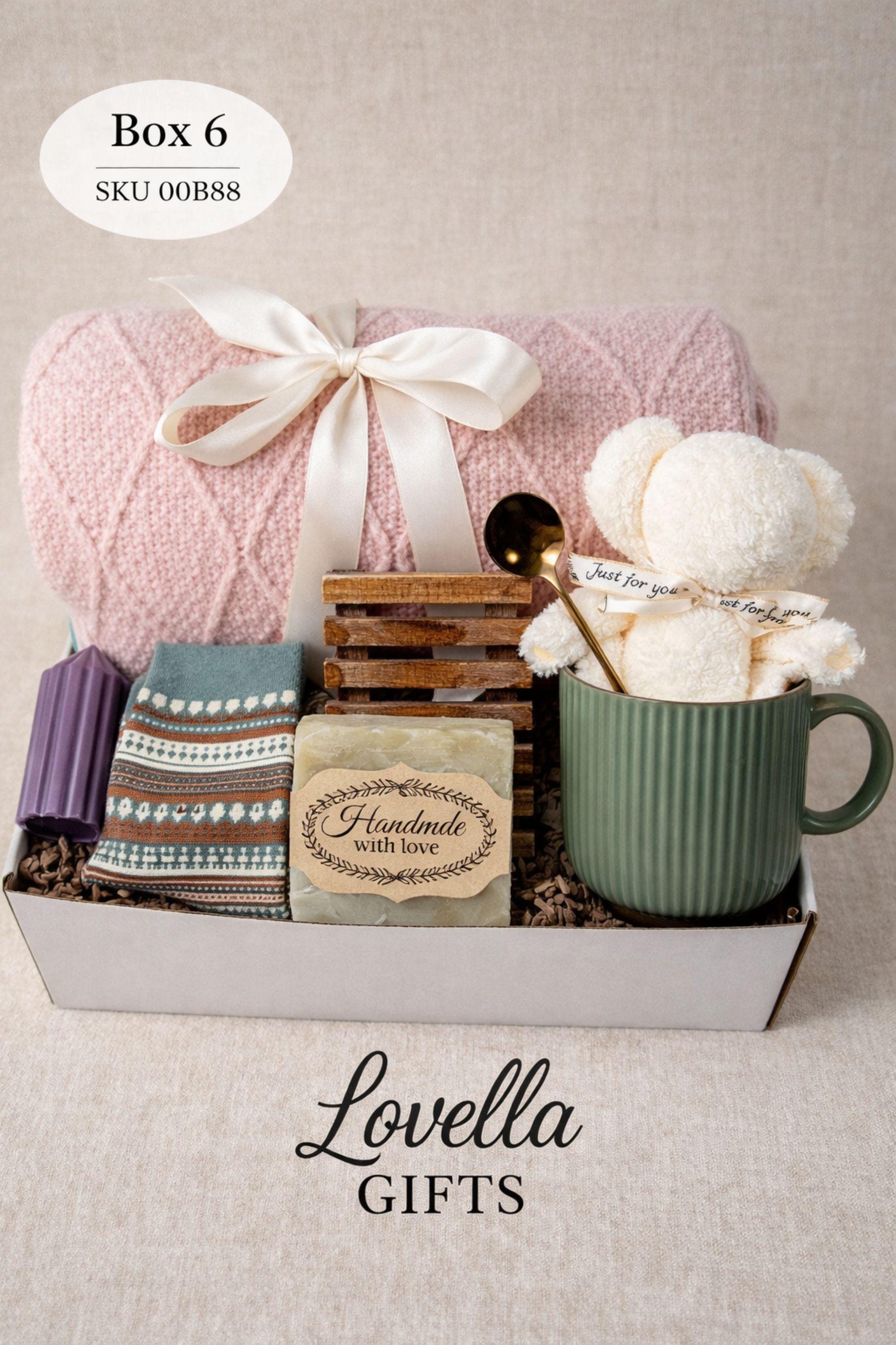 Breakup comfort gift box with cozy blanket, ceramic mug with gold spoon, plush teddy bear, handmade soap and face cloth arranged in gift box. Emotional support care package designed as a healing self care gift and thinking of you gift for friend going through breakup or difficult time.